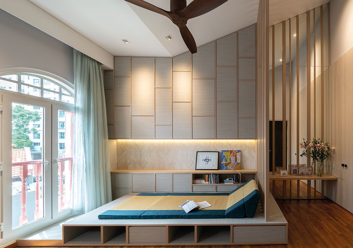 The linear detailing on the walls highlights the original architectural features of the shophouse