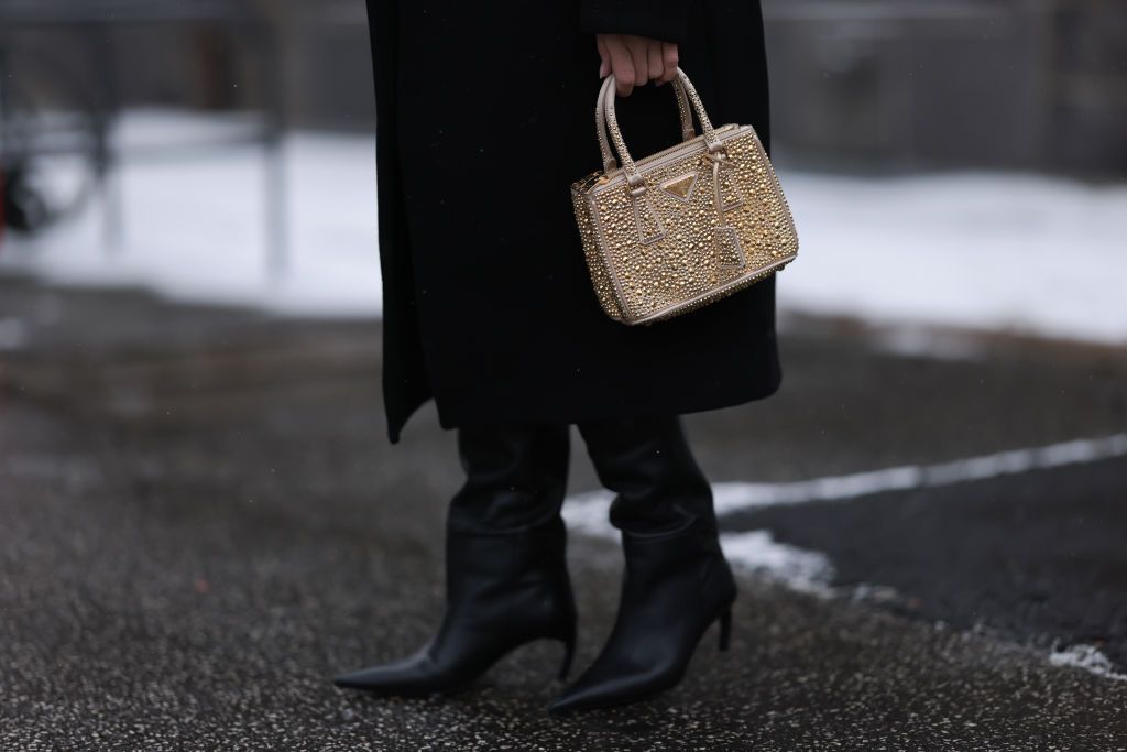 BERLIN, GERMANY - NOVEMBER 29: Sonia Lyson seen wearing Cos black fake fur long coat, Prada gold studded glitter bag and Cos black leather high overknees / boots, on November 29, 2023 in Berlin, Germany. (Photo by Jeremy Moeller/Getty Images)