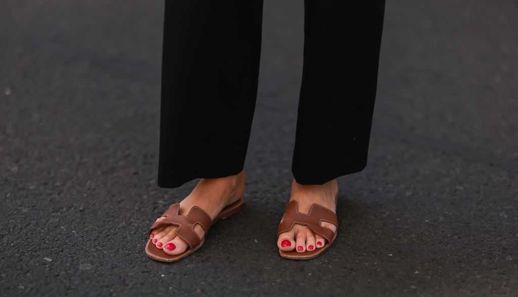 BERLIN, GERMANY - JULY 28: Leo Eberlin is seen wearing Hermes brown leather Oran sandals and Uniqlo black pants on July 28, 2022 in Berlin, Germany. (Photo by Jeremy Moeller/Getty Images)