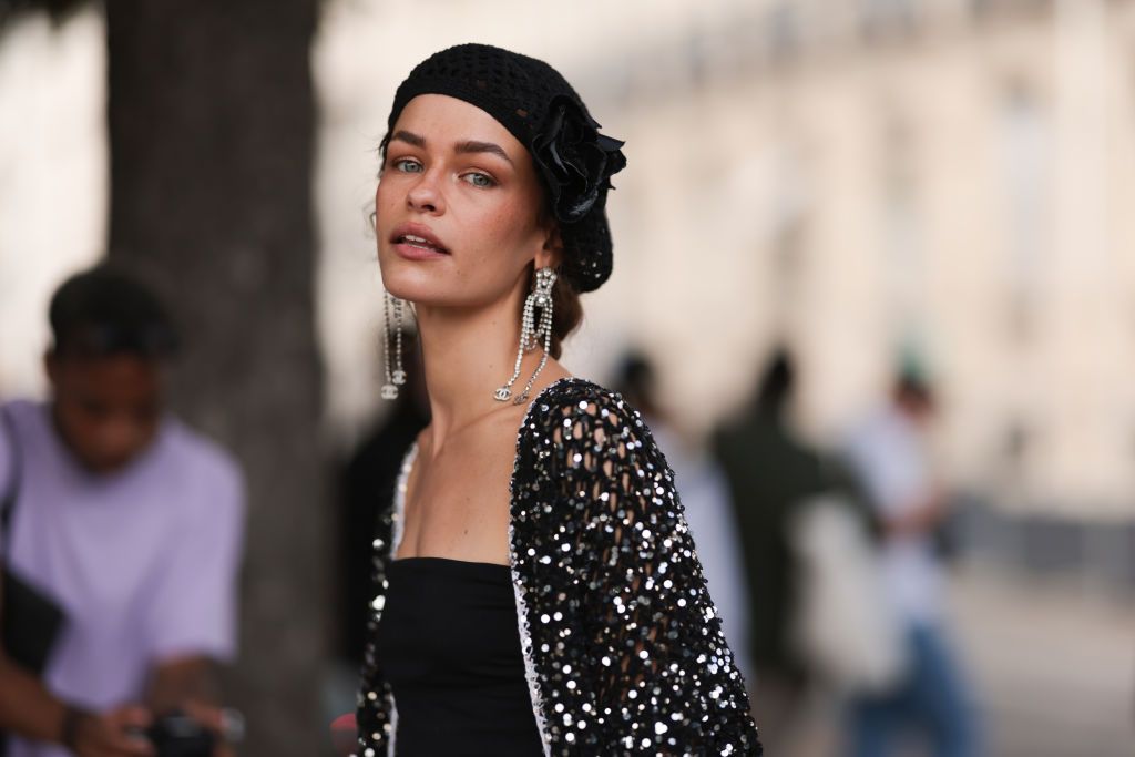 PARIS, FRANCE - JULY 04: Melanie Kieback seen outside Chanel show wearing black barret, crystal earrings, black bandeau top, glittery Chanel jacket and matching skirt, vintage Chanel leather handbag and black leather vintage boots during the Haute Couture Fall/Winter 2023/2024 as part of Paris Fashion Week on July 04, 2023 in Paris, France. (Photo by Jeremy Moeller/Getty Images)