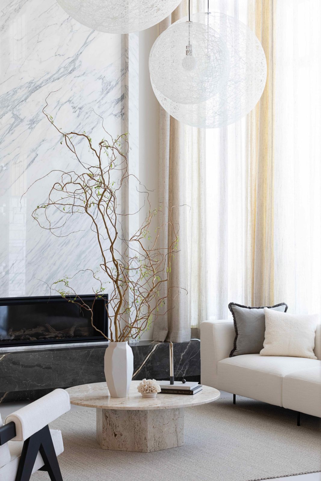 A travertine coffee table and Moooi ceiling light fixture