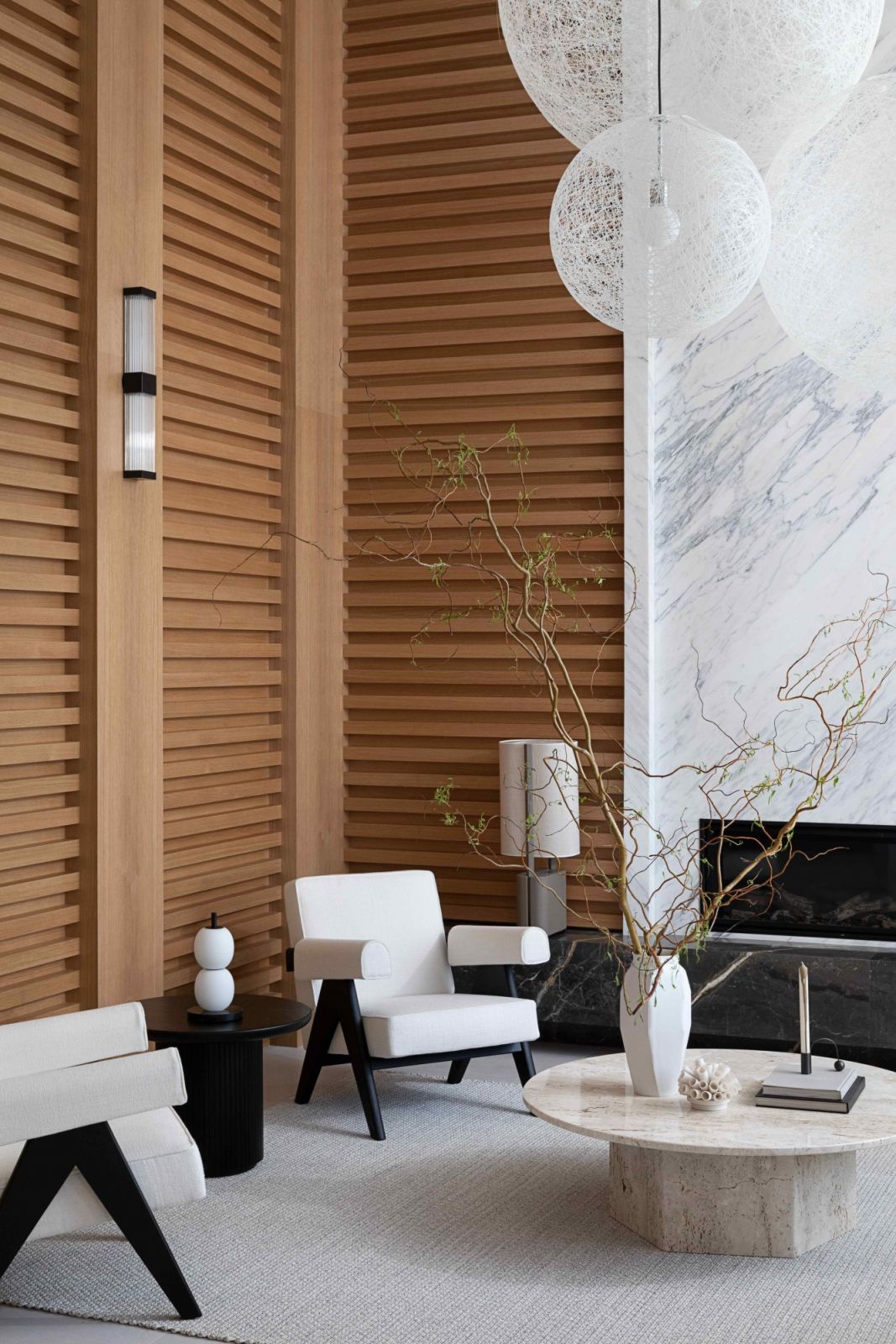 A white oak backdrop complements the veined marble wall