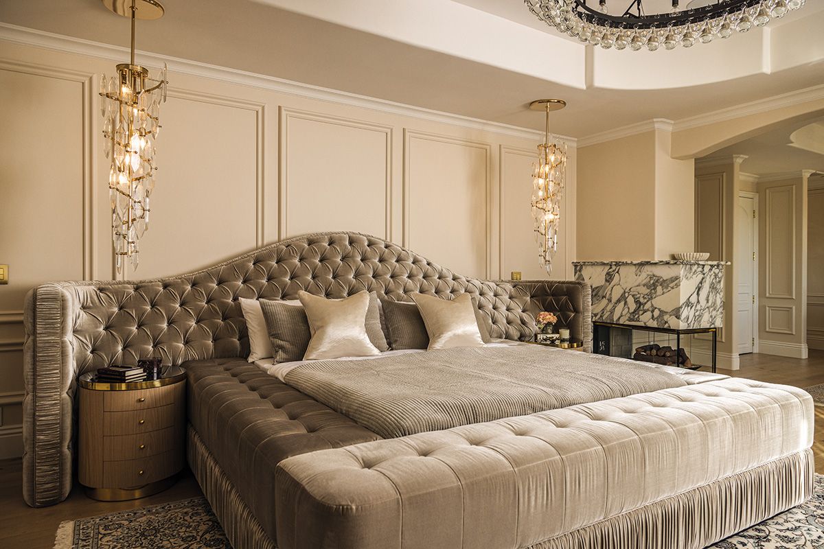 The master bedroom features a handsome bed with tasselled details and a headboard made with Pierre Frey fabric
