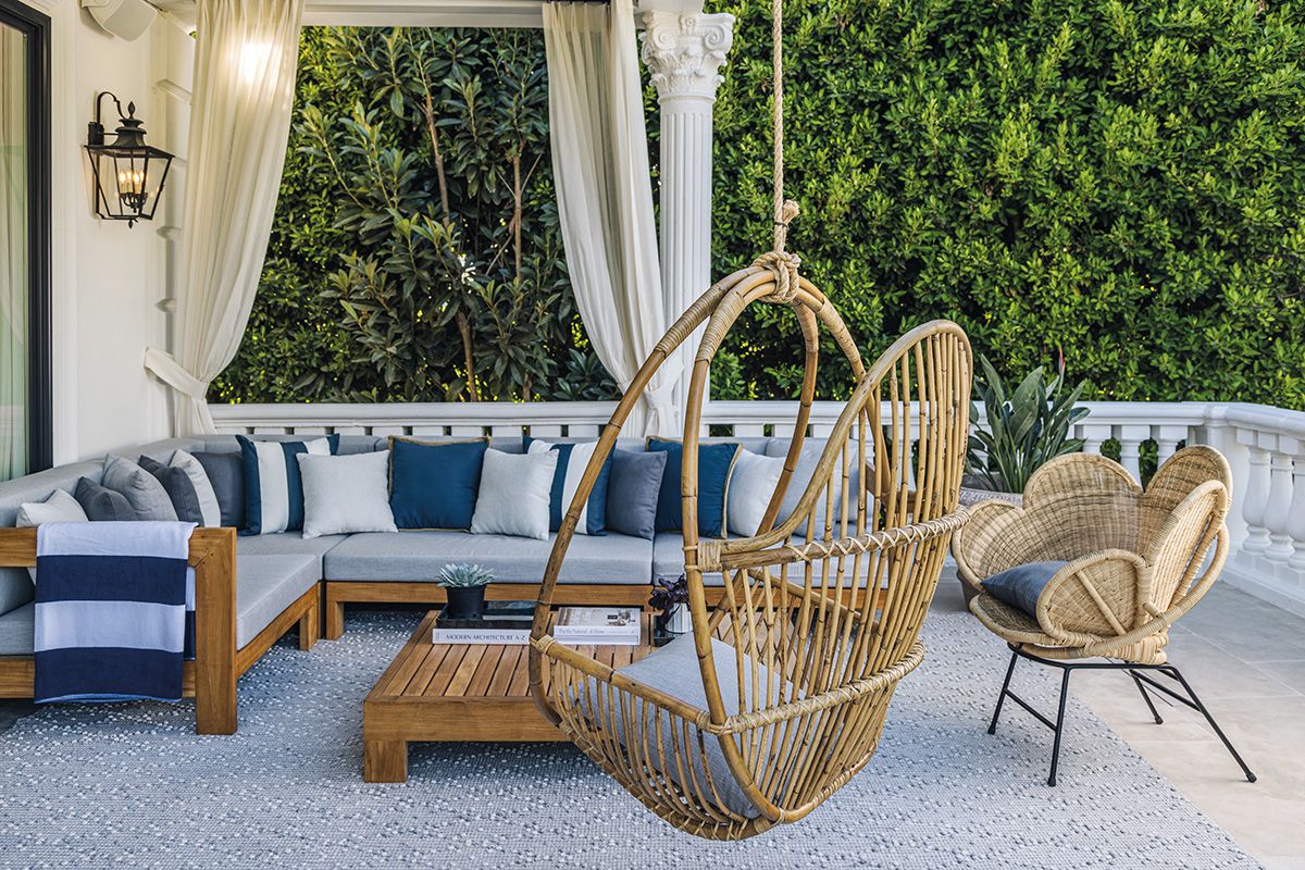 The cosy outdoor area features rattan and teak furnishings to create a relaxed vibe
