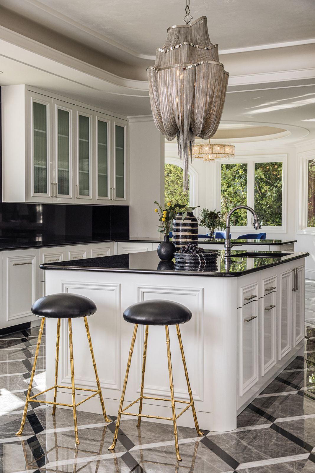The kitchen features a Terzani chandelier, Rose Uniacke bar stools and bespoke cabinets