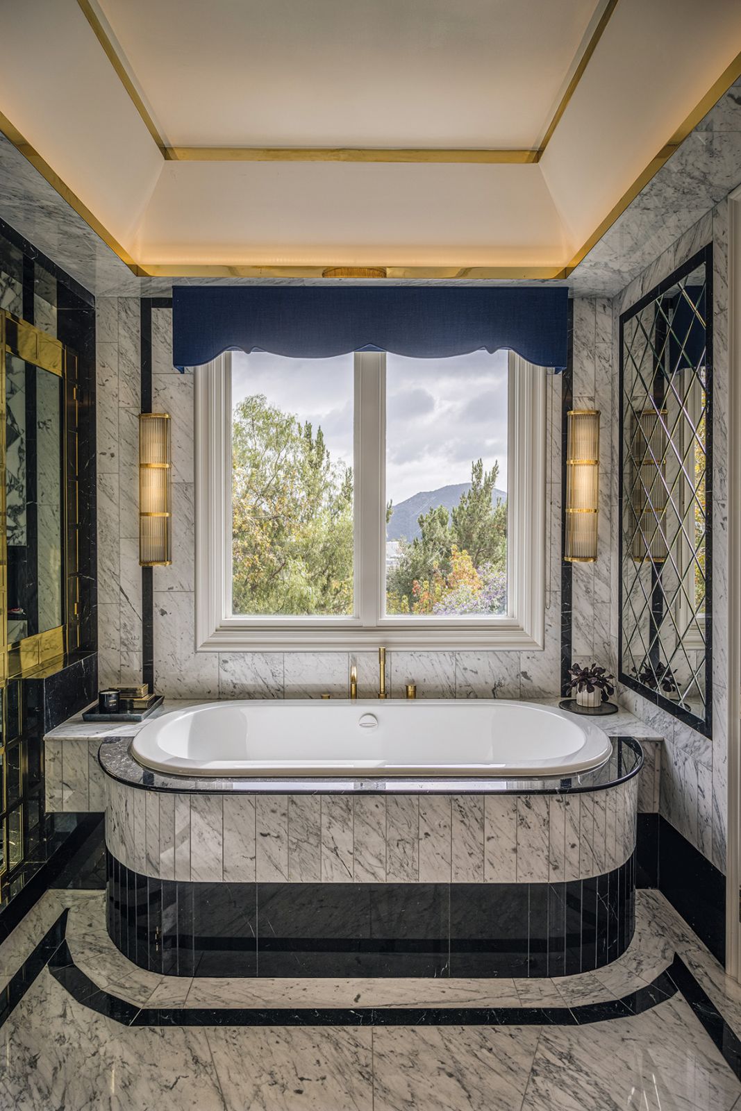 Mirrored details and intricate inlaid stone tiles amplify the glamorous look of this bathroom