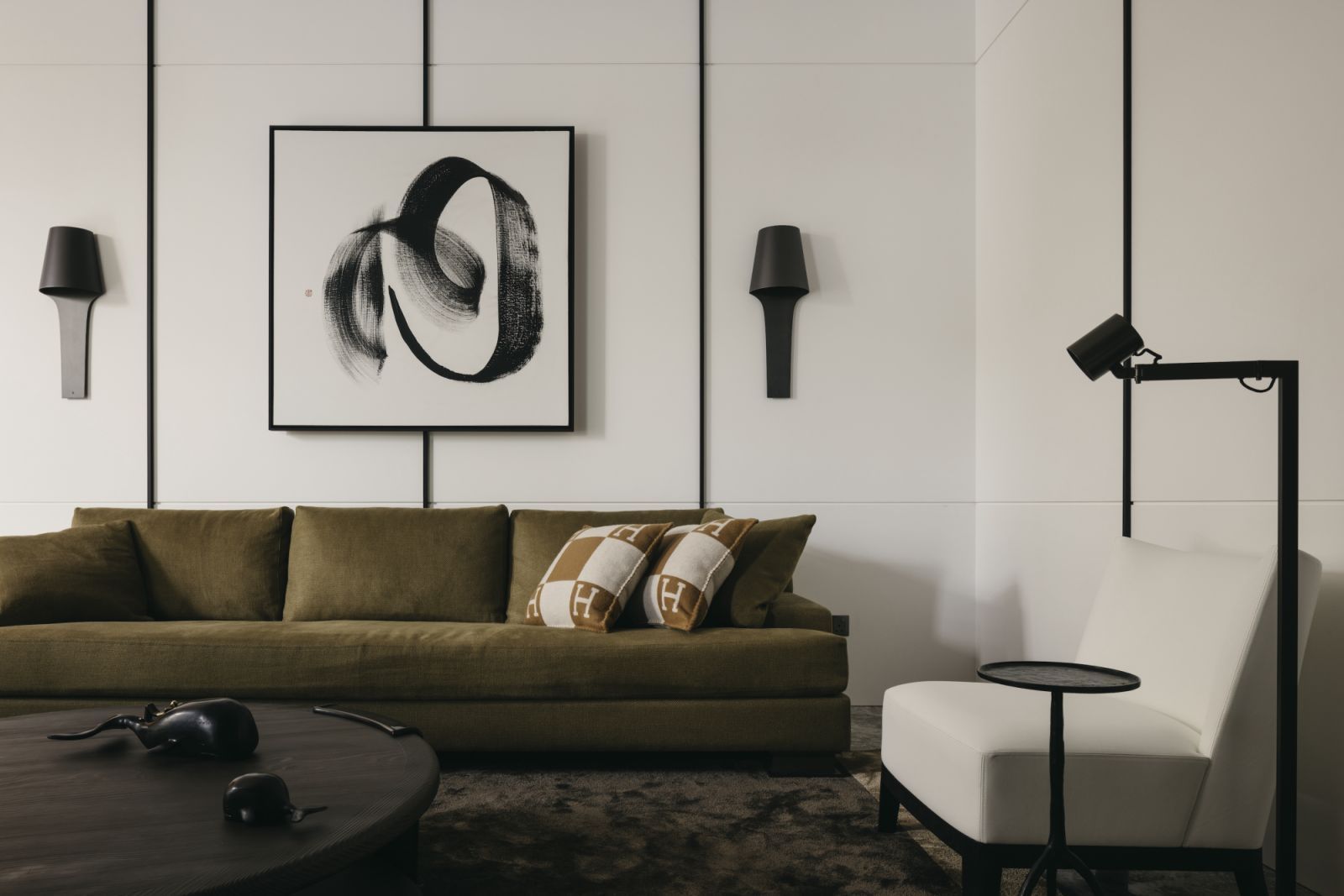 The olive-green Hunier sofa from Liaigre is paired with a work by local artist Simon Wee