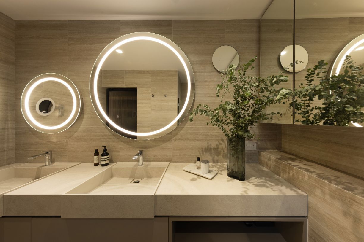 Backlit mirrors bring a soft glow to the master bathroom