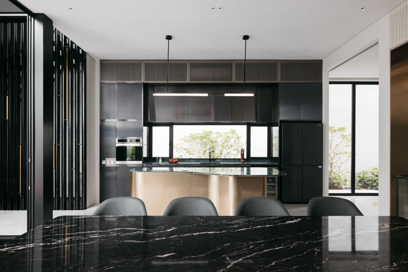 The black marble dining table and the champagne-gold finish of the curvy island bring opulent touches to the modern scheme