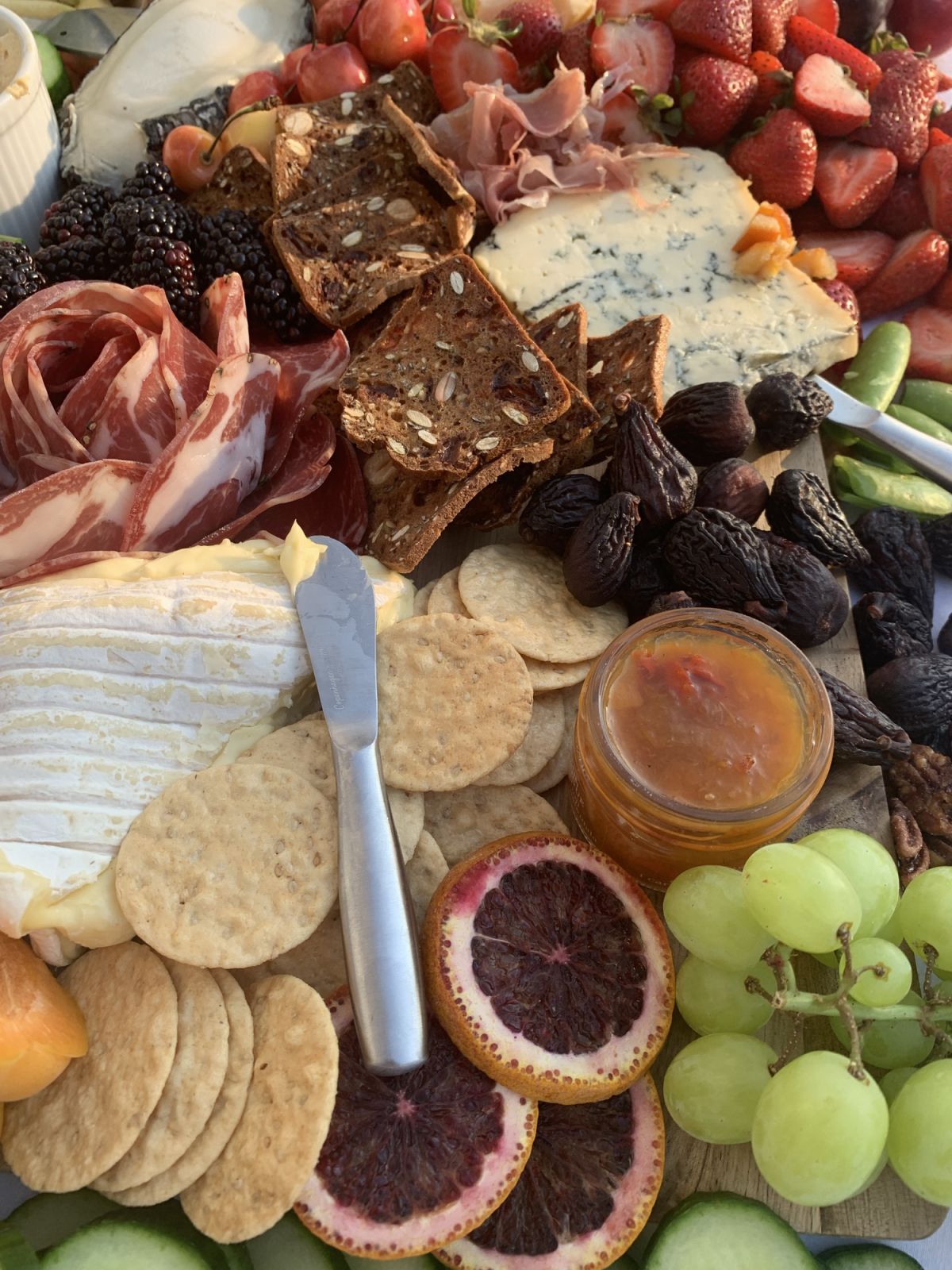 A grazing platter featuring fruits and crackers