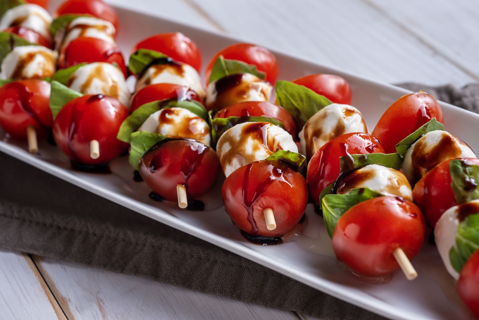 Caprese salad skewers drizzled with balsamic glaze