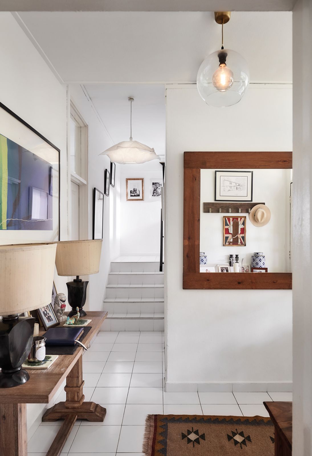Every corner of the home is decorated with family photos, memorabilia and an eclectic mix of art, as seen in the entryway and at the staircase landing