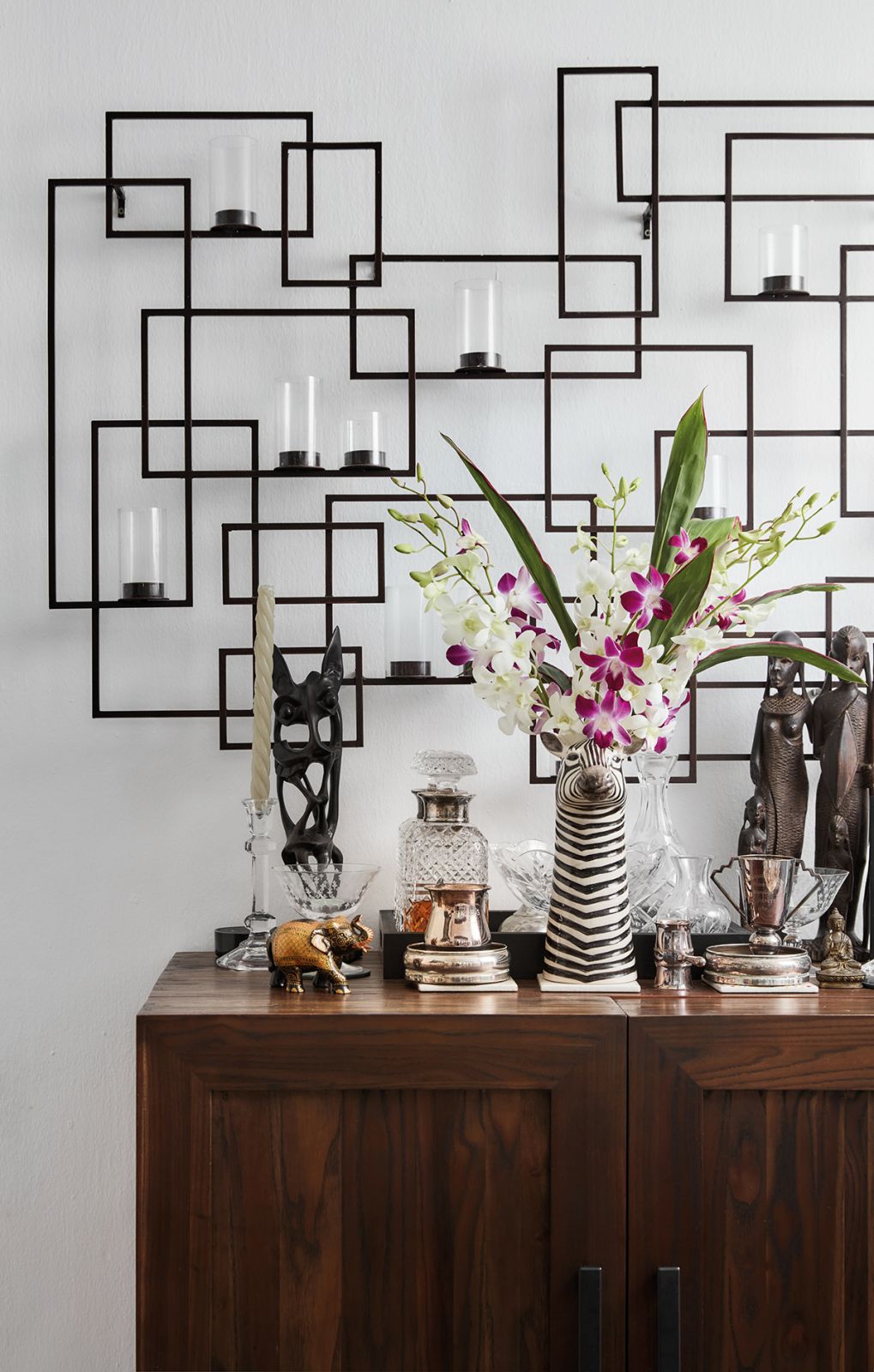 Elegantly contrasting with the wooden sideboard below, modern geometry adorns this area of the home