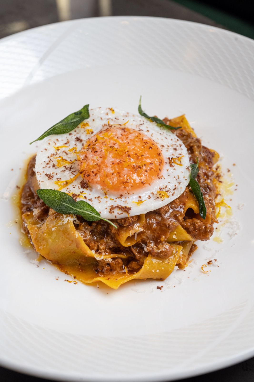 Pappardelle dressed with duck ragu and topped with a fried duck egg