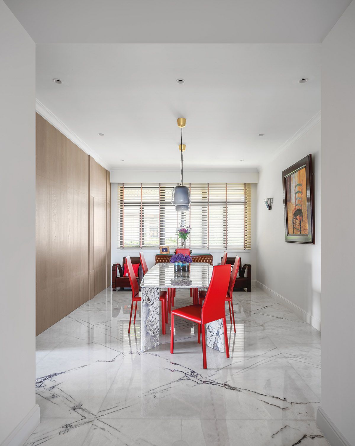 A set of bold red dining chairs instantly elevates the dining area, which also features a bespoke table commissioned from Industry+