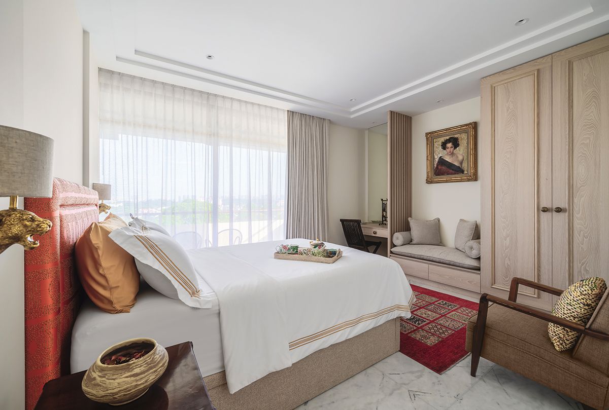 This bedroom connects to a balcony that invites ample daylight into the space