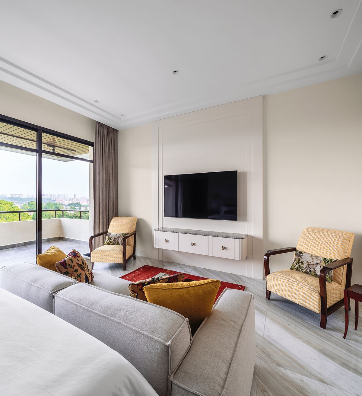 A red rug adds spice to the sitting area in the master suite