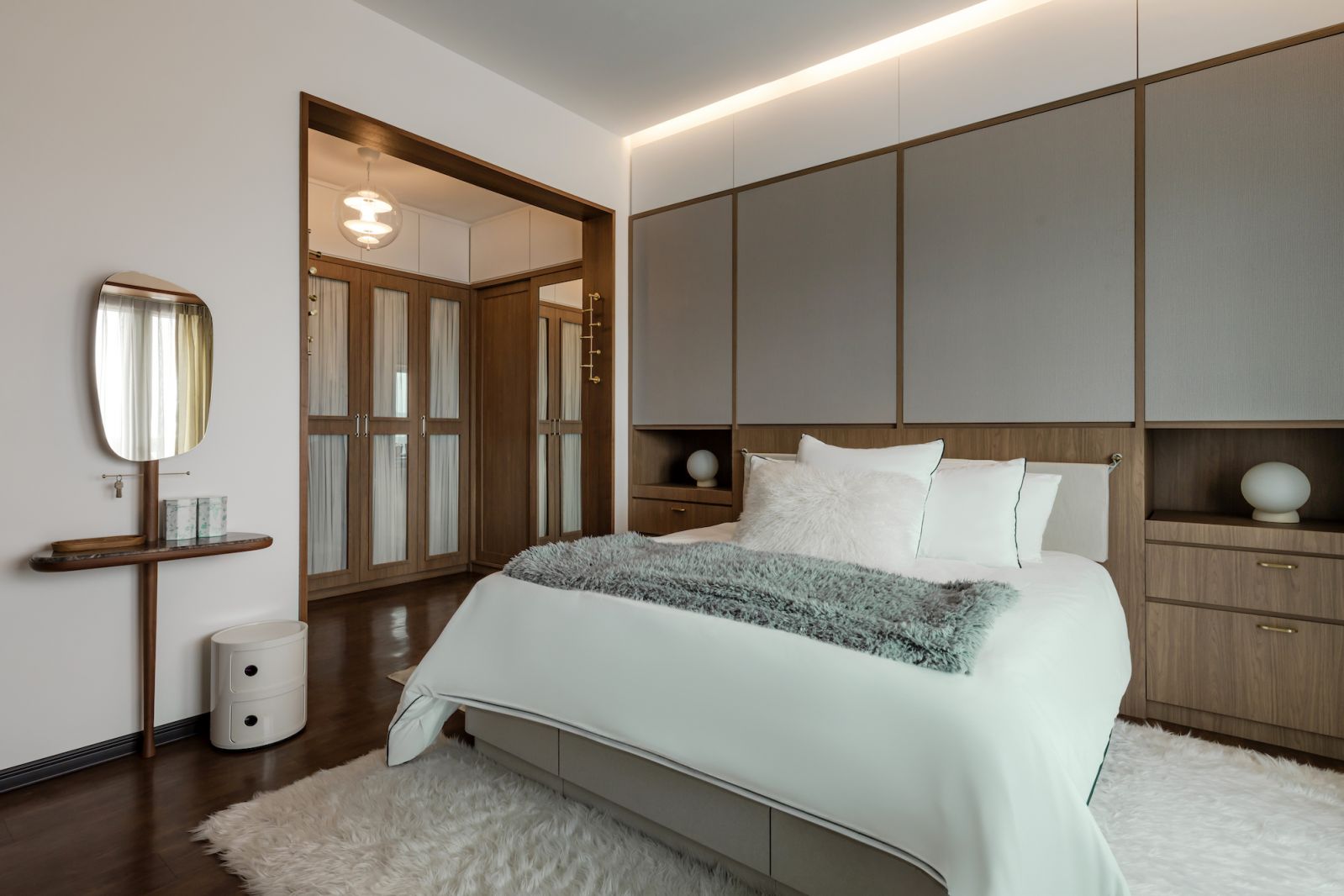 The bedroom has a neutral colour palette with warm wood accents