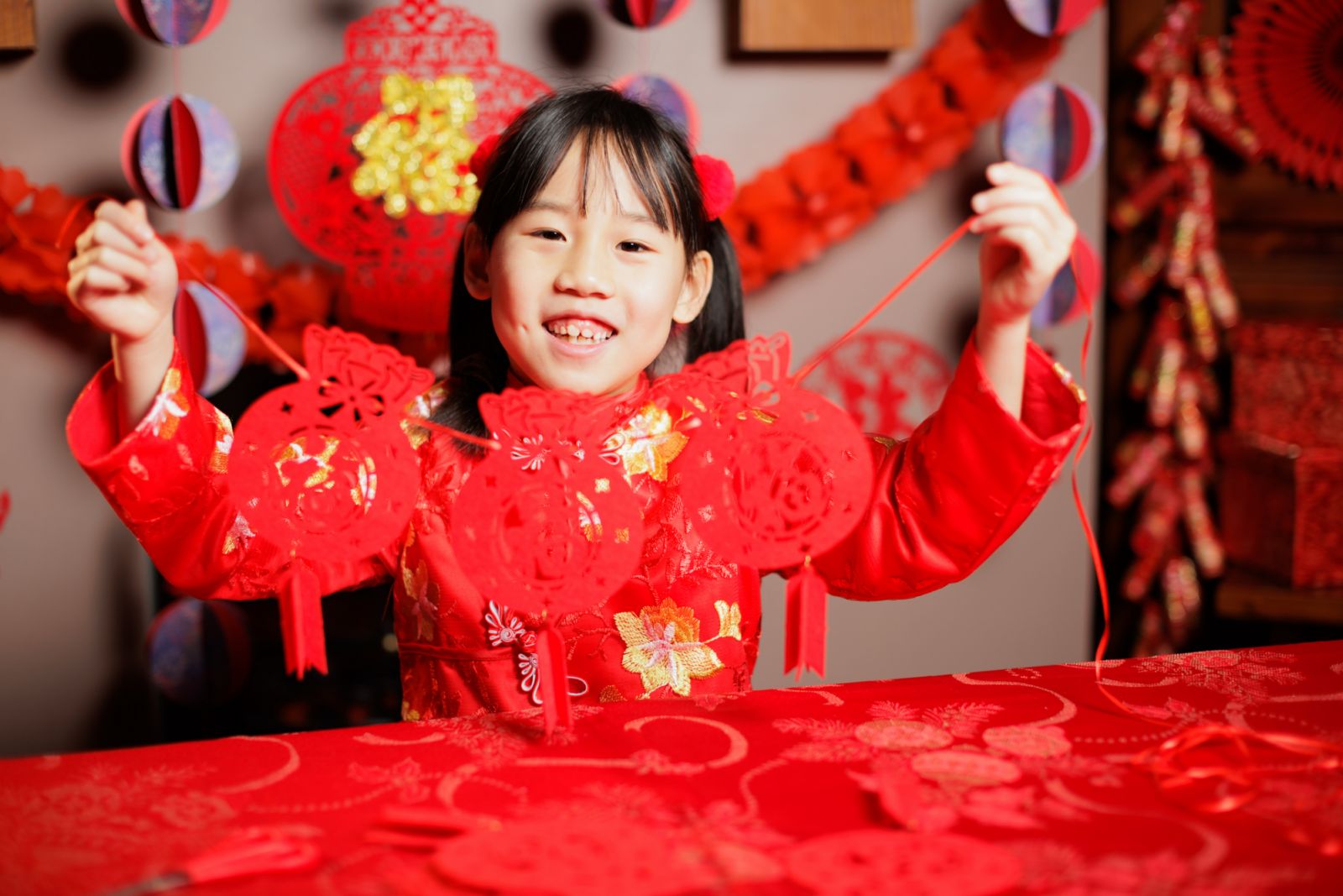 medium shot of young Chinese girl celebrating Chinese new year at home