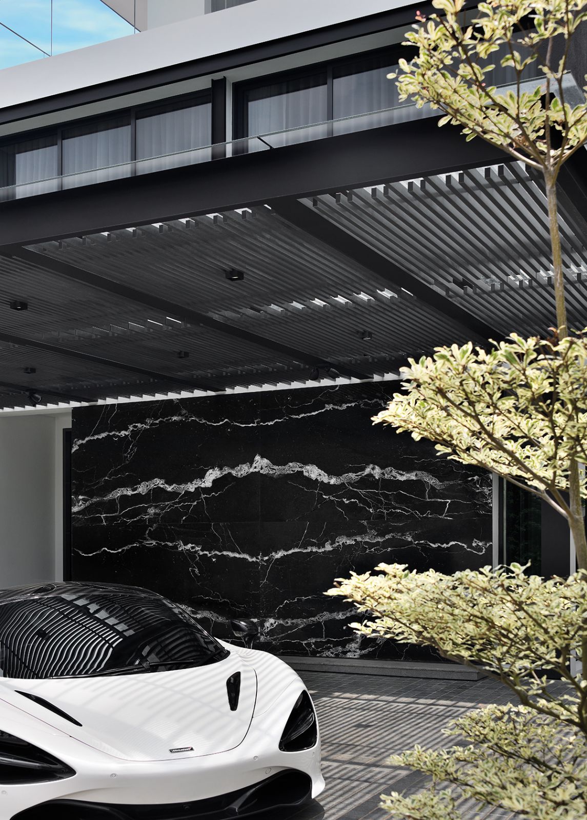 Bookmatched marble tiles create a grand impression at the car porch