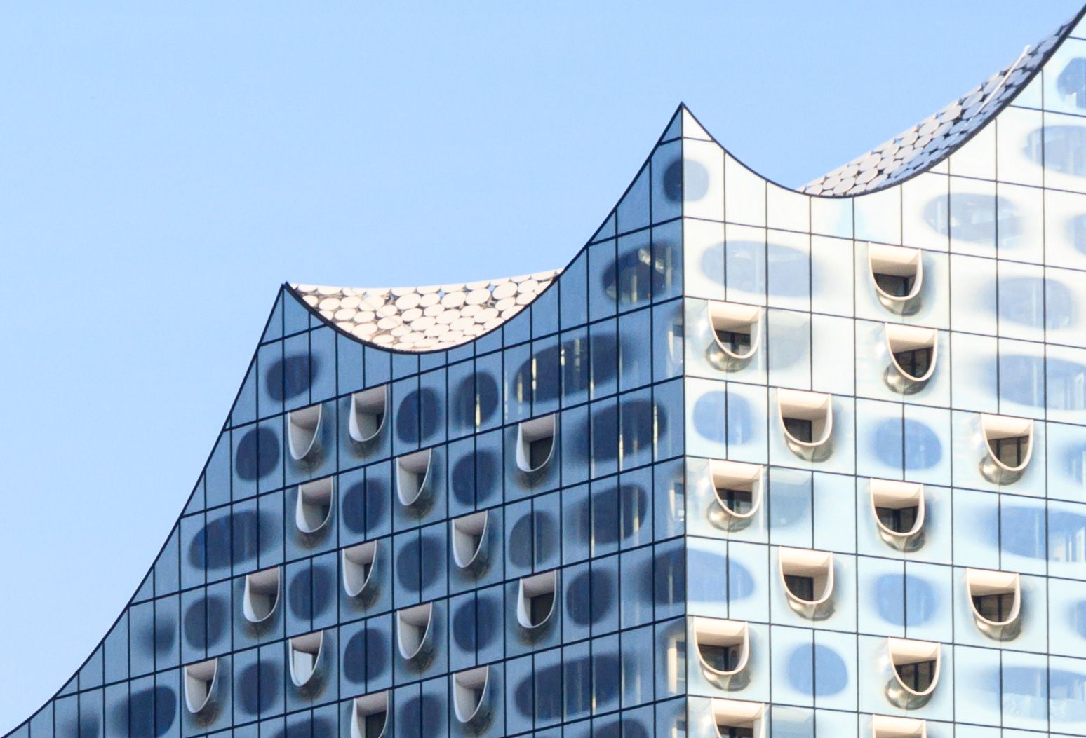 An undulating roof line reminiscent of a hoisted sail or the surrounding waves (Photo: Matthias Suessen / WikiCommons)