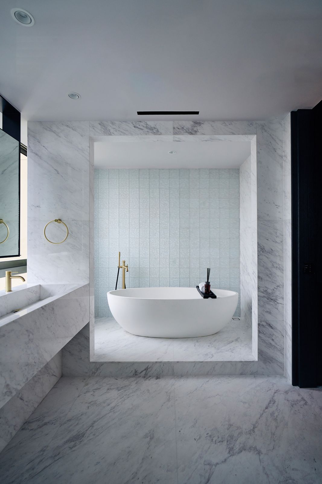 The master bathroom sets the stage for bathing rituals with an elevated platform for the bathtub