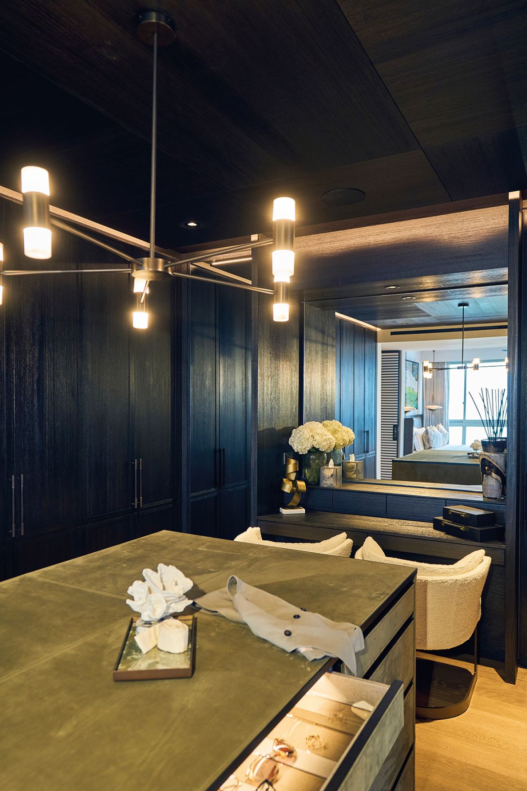 A green leather-clad island is among the richly textured details in this dressing room