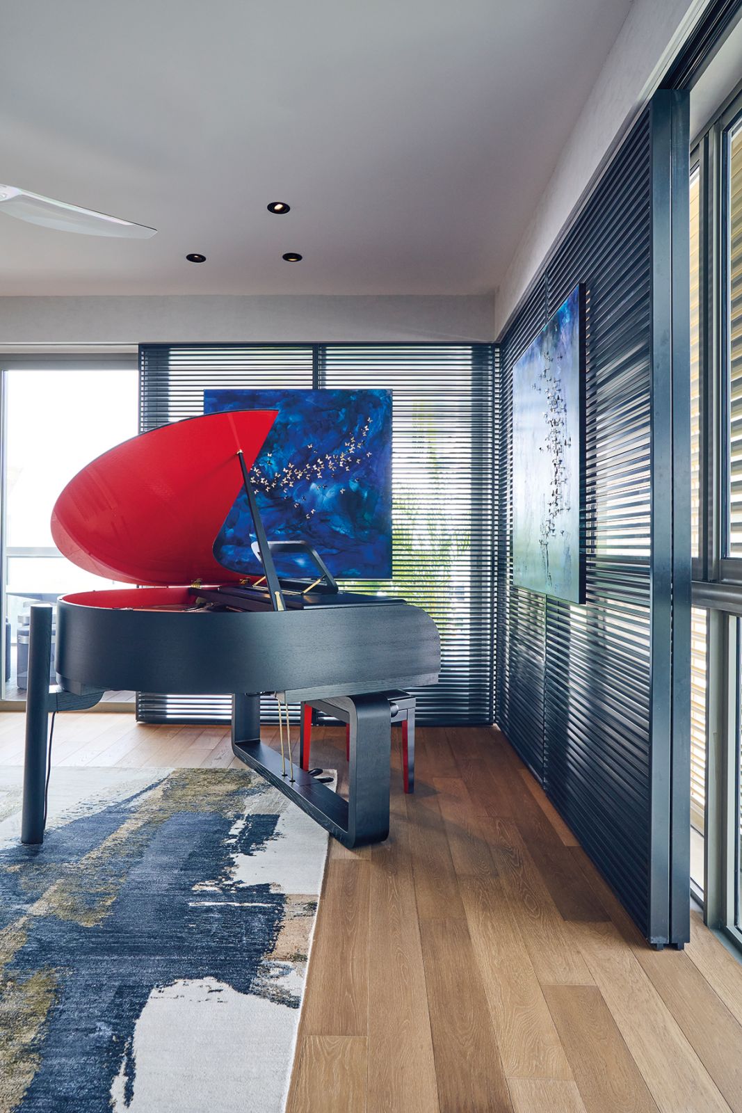 The sculptural form of the baby grand piano makes it the anchoring piece of this space
