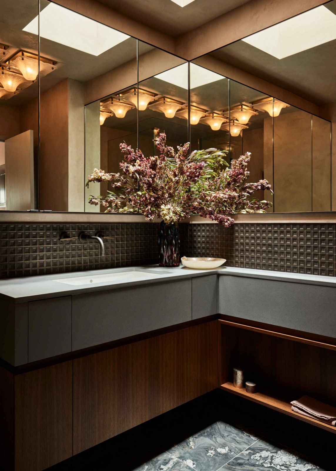Deep blue stone and earthen tiles accentuated by an auction-acquired light fixture