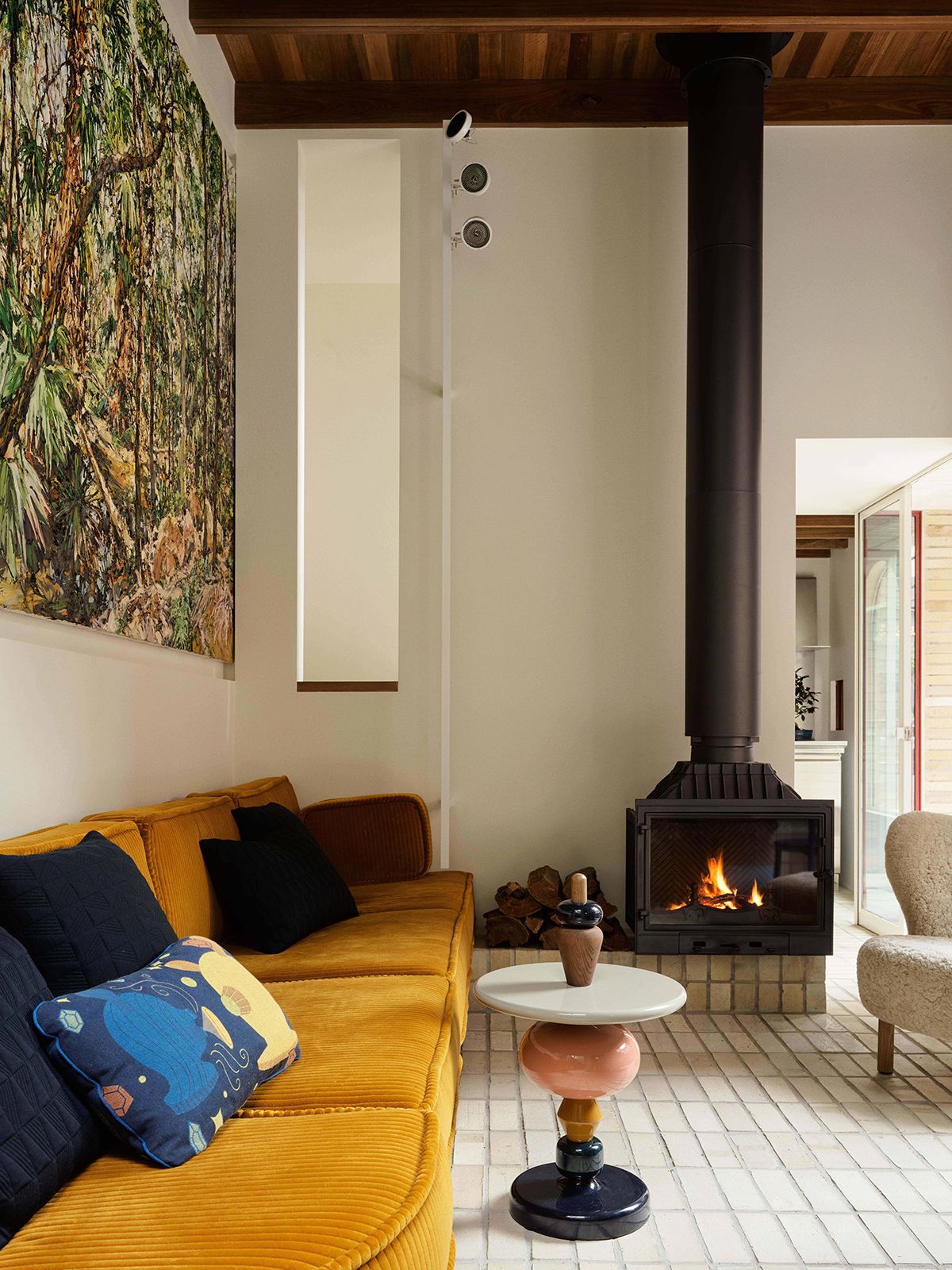 A quietly charming living area complete with muted pops of colour and a fireplace for cosy nights at home