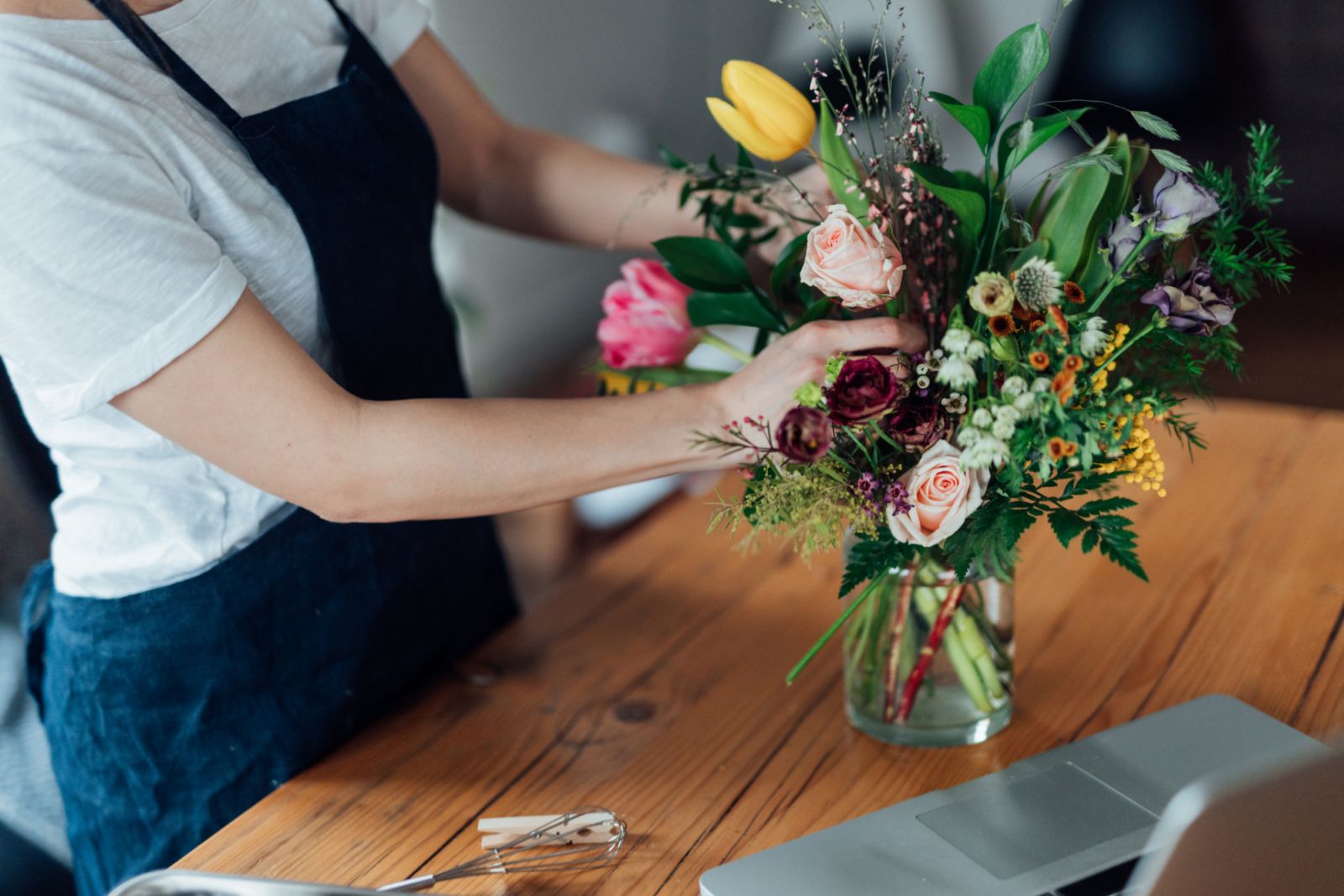 Cropped shot of young beautiful woman arranging fresh flowers in her living room.
