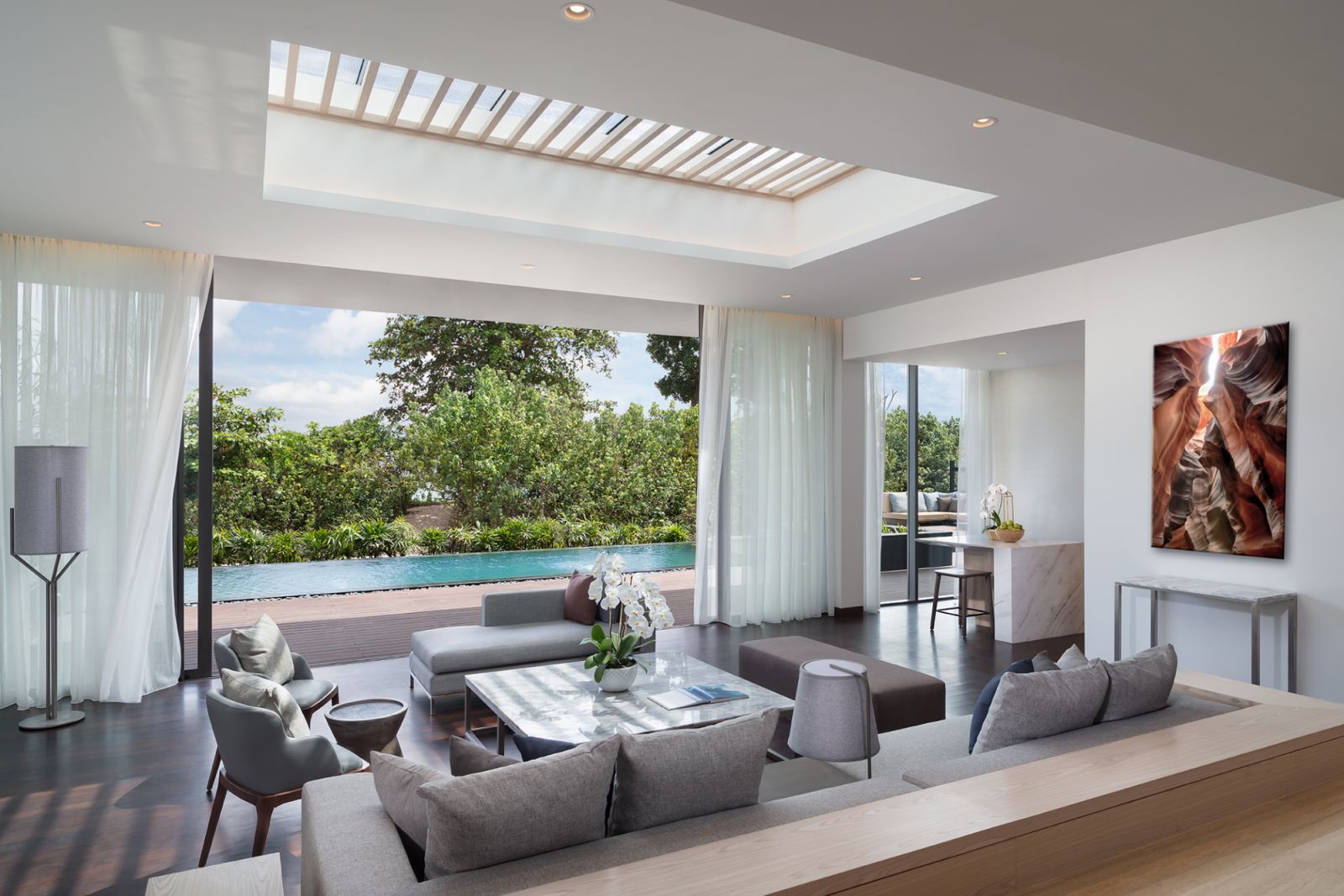 The living room of the 3 bedroom residence opens out onto a sundeck and private pool
