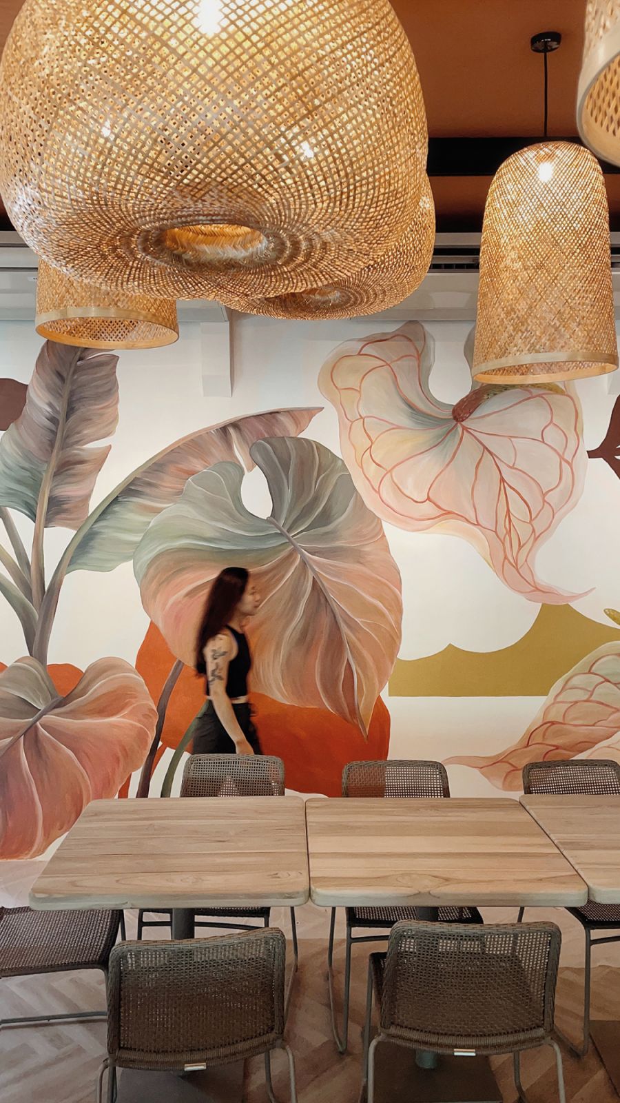 Artist Geraldine Toh walking past one of her large-scale murals
