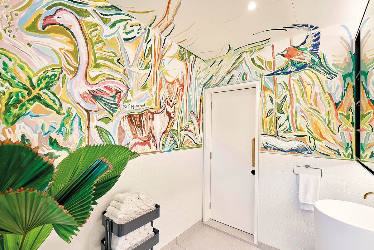 A wrap-around mural evokes the jungle in this powder room