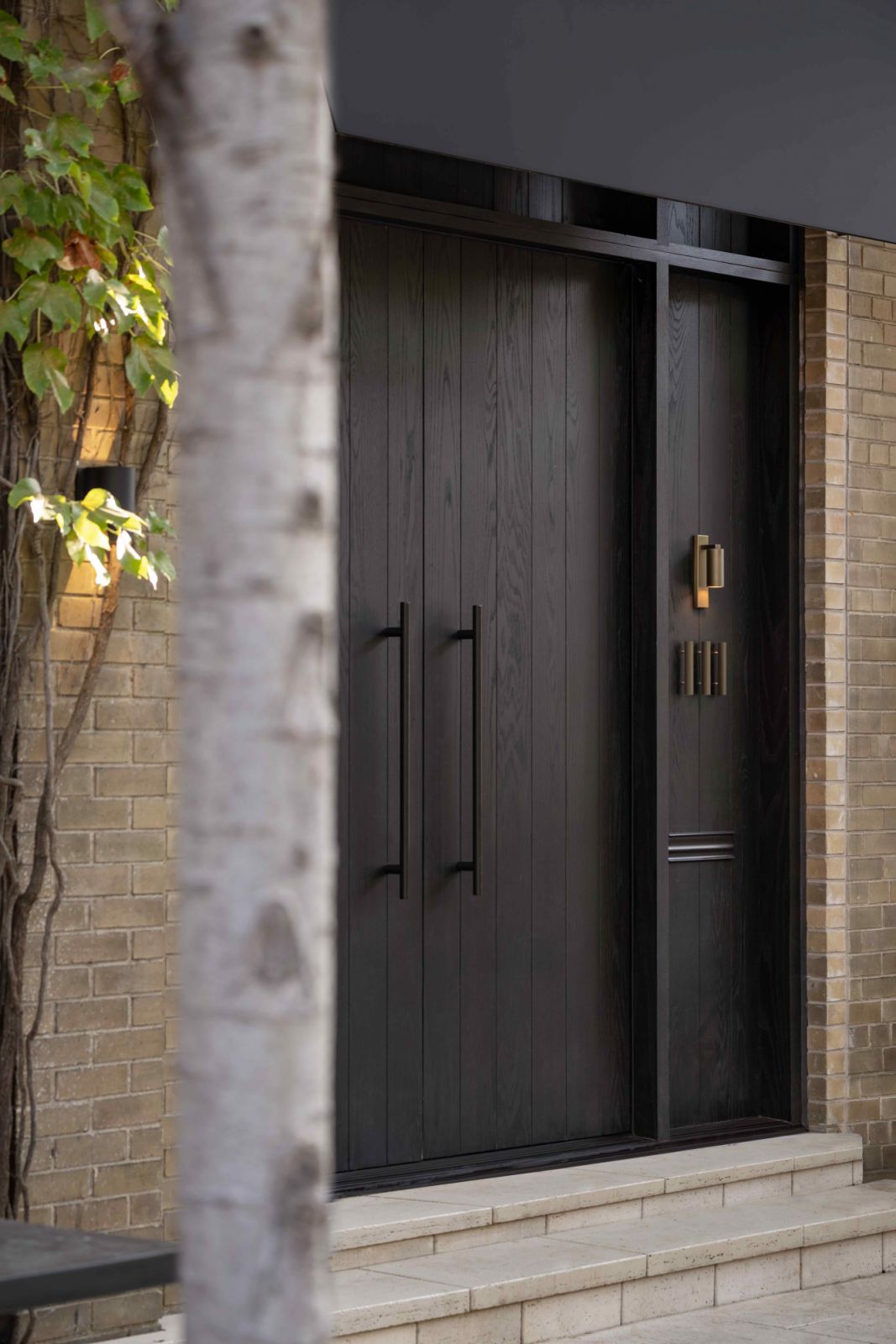 The front entrance with large, black-stained oak doors.
