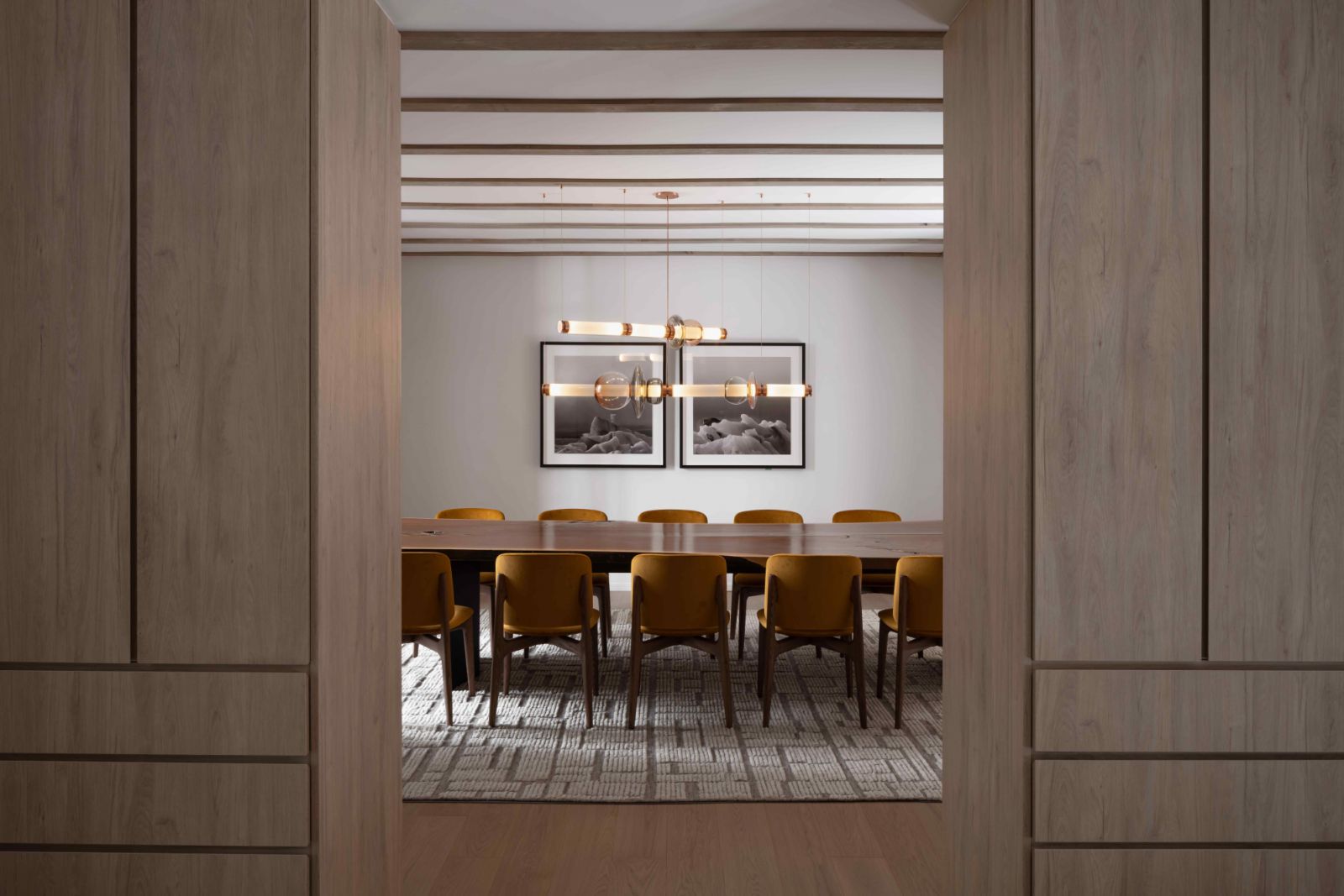 A mustard-toned dining area with oak timber cabinets
