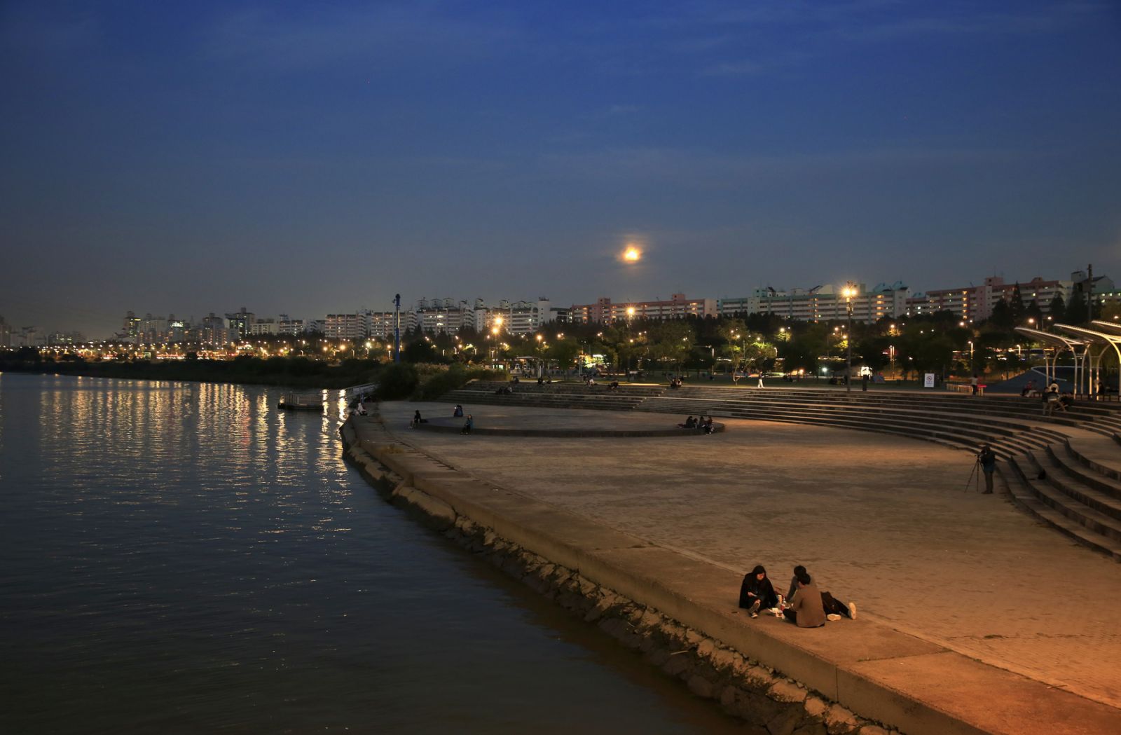 Locals sitting on the bank of the Han river at night