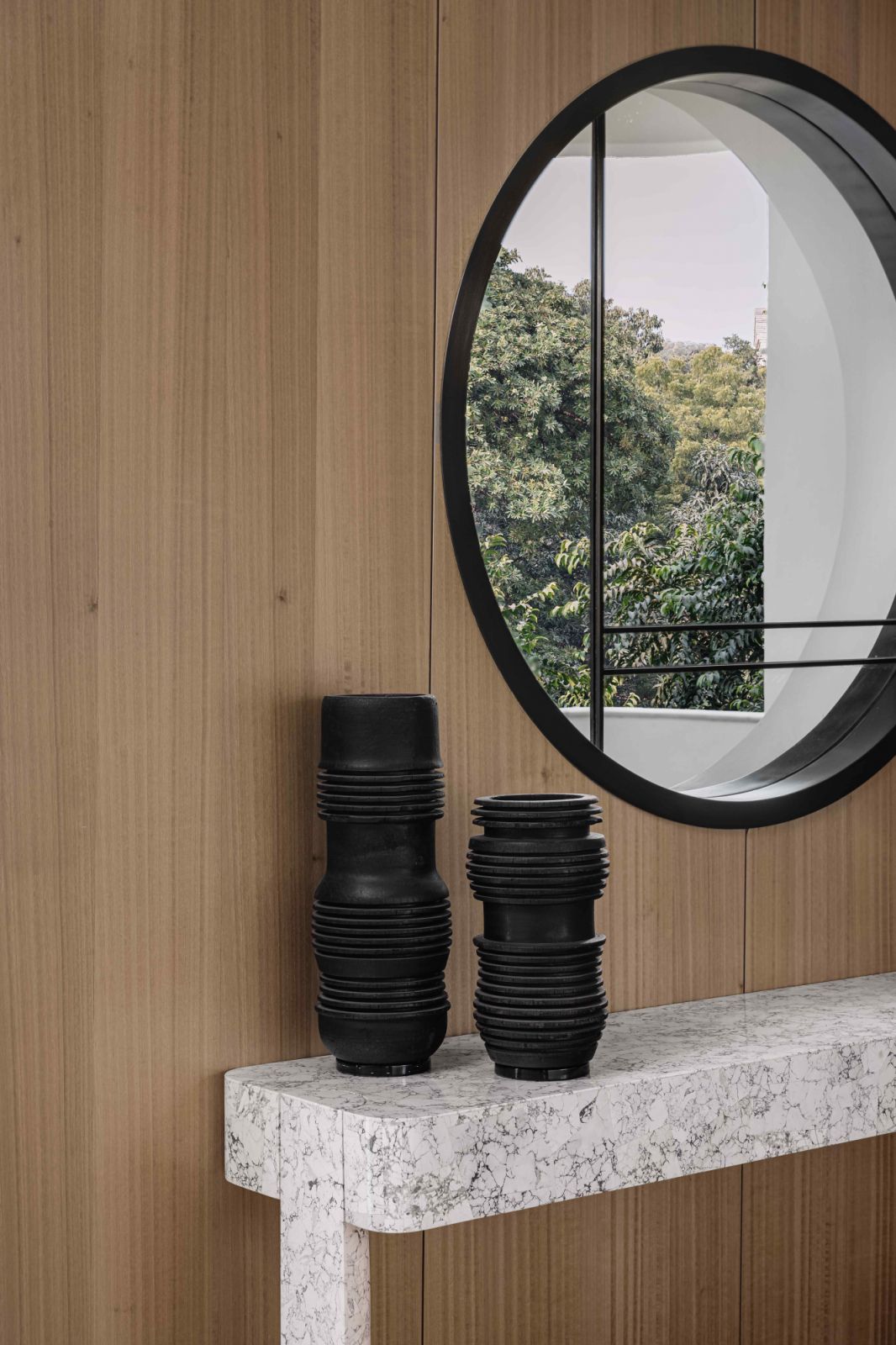 A bronze-framed circular window with DeMuro Das-designed howlite console