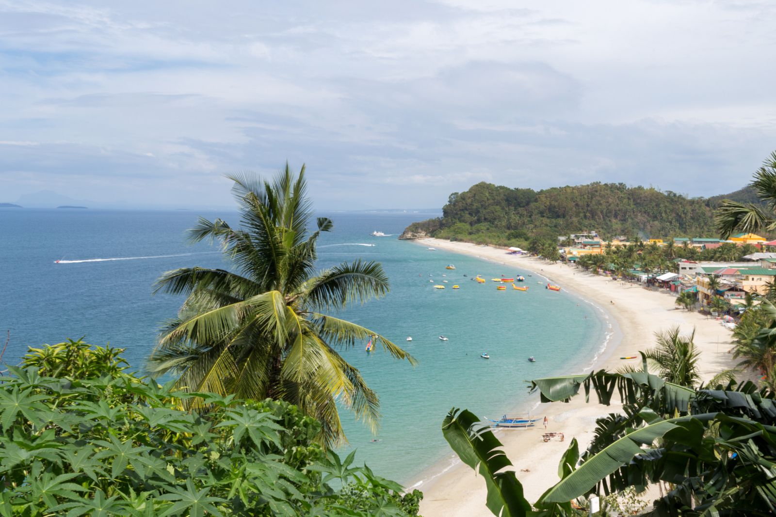 Sea, blue sky, palms and boats in White beach, Puerto Galera, Philippines. Popular tourist and diving spot. (Photo: GettyImages)