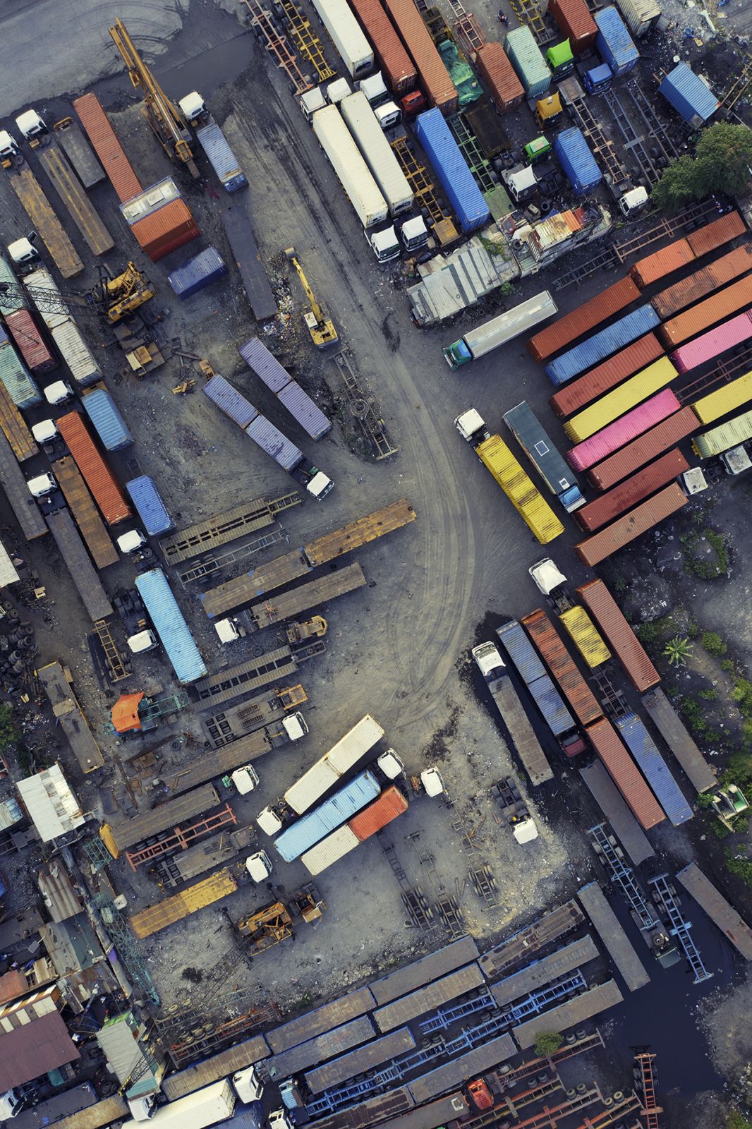 Lots of trucks, trailers and containers in mixed colors and condition.