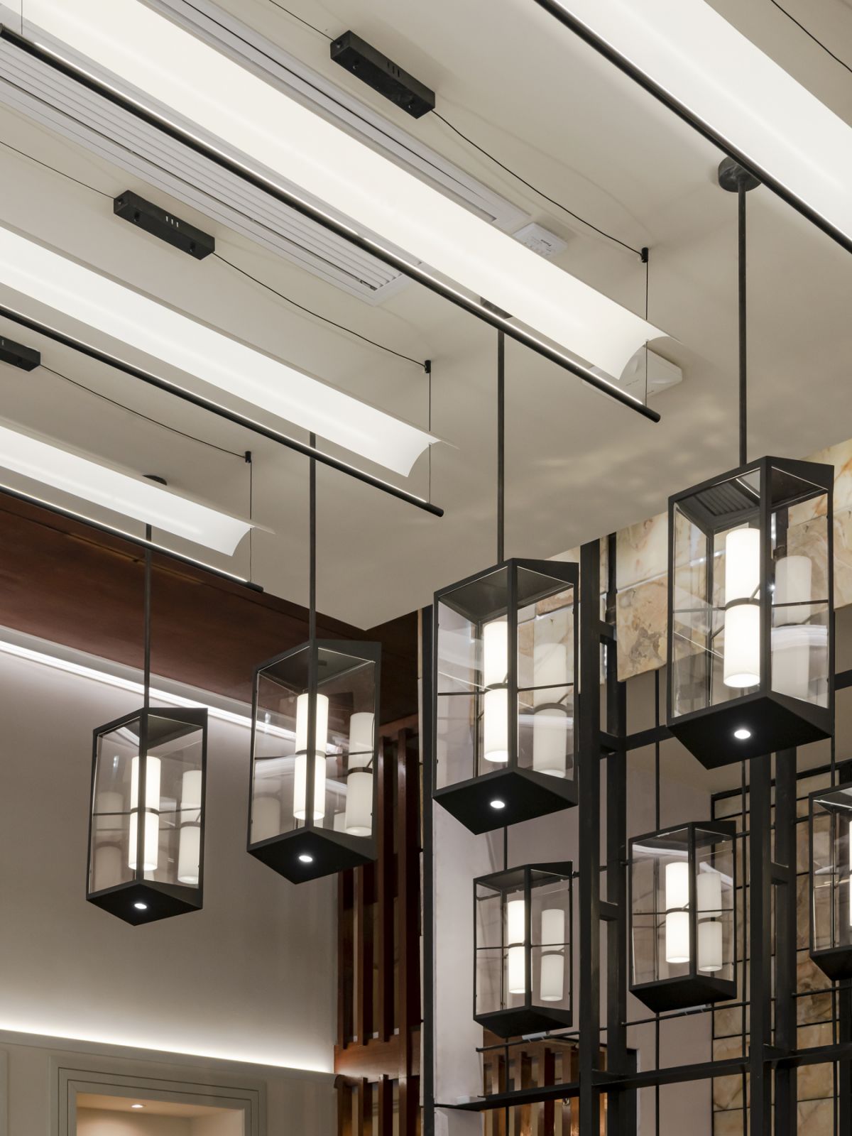 Custom pendant lights pay homage to the rhythmic design cues of the building's façade