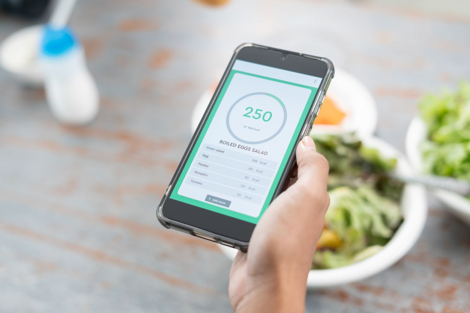 Calories counting application on smartphone. Young women using application healty control for her daily calories eating salad. Diet plan for dailylife.