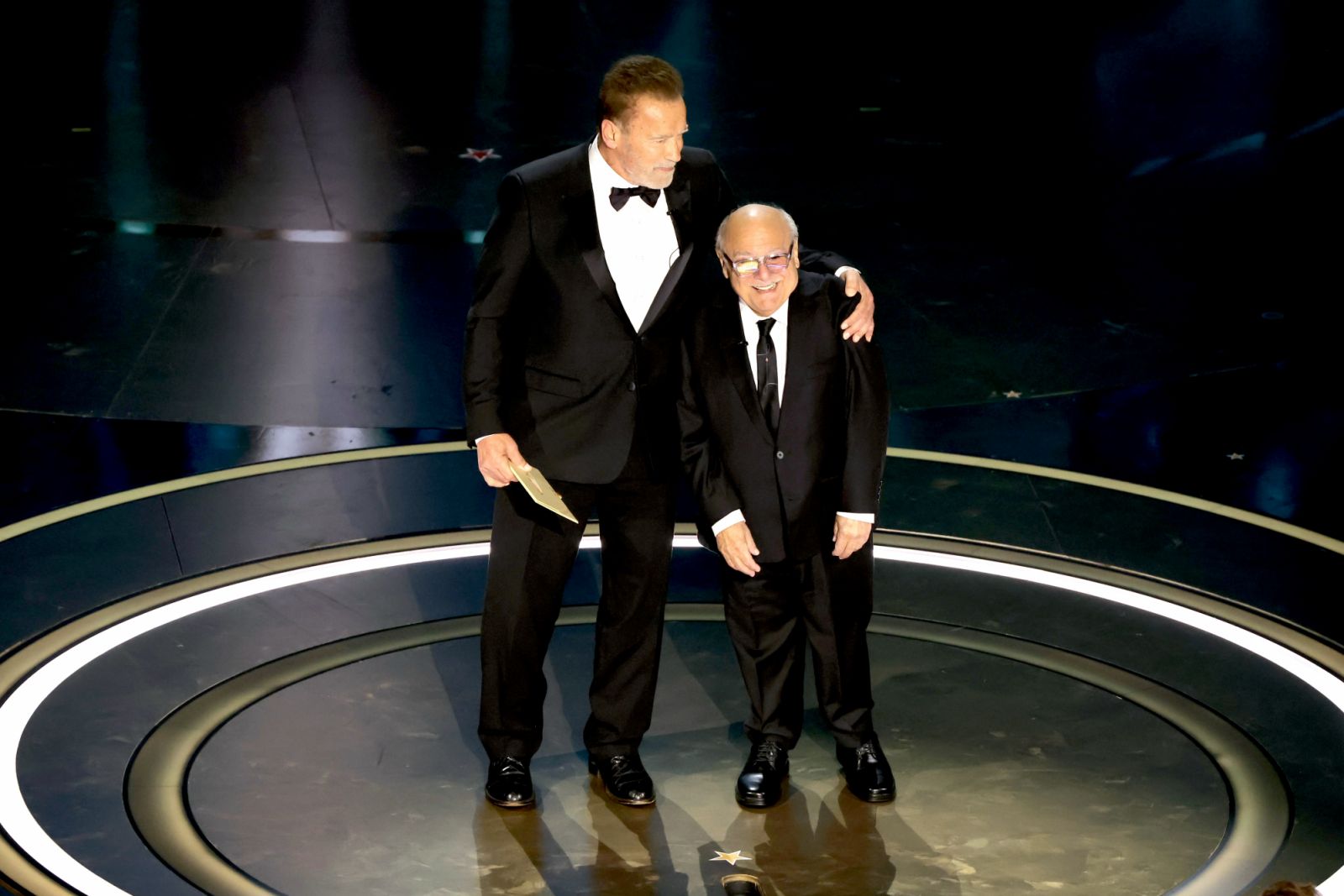 Arnold Schwarzenegger and Danny DeVito speak onstage during the 96th Annual Academy Awards (Photo: Kevin Winter/Getty Images)