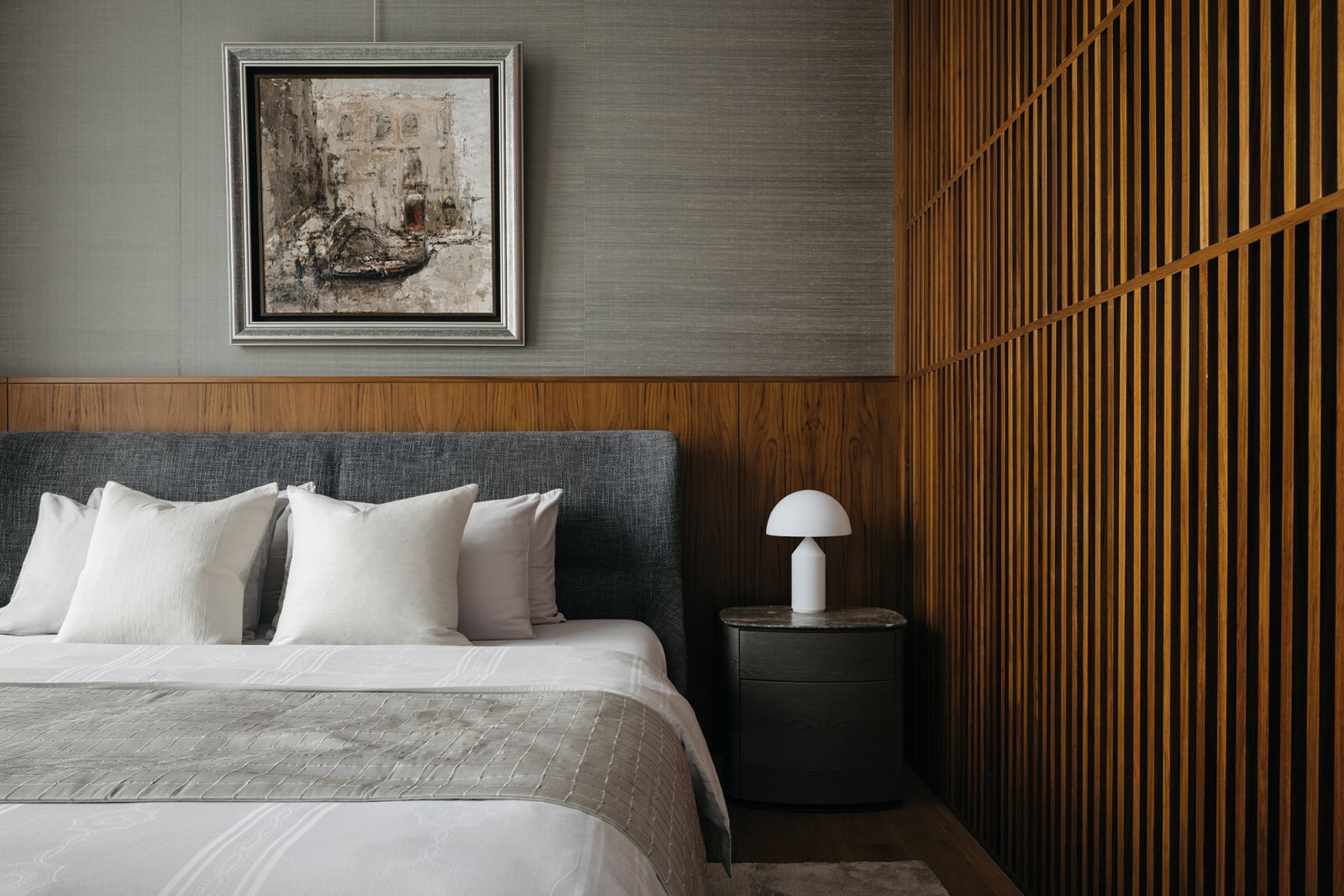 Slatted teakwood wall panels impart a linear, rustic touch to the master bedroom