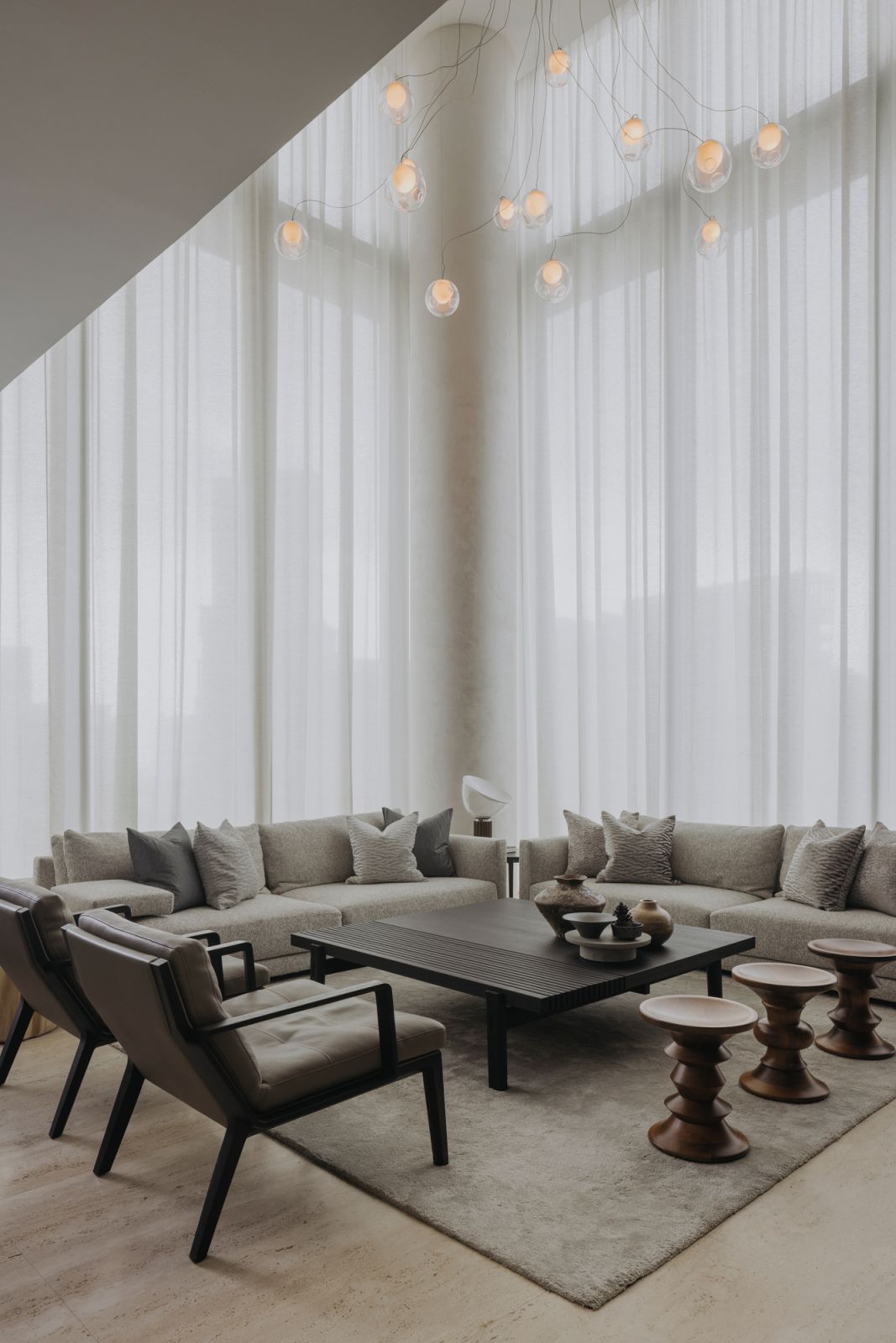 The lofty dimensions of the double-height living area play up the celestial-inspired arrangement of these Bocci suspension lights