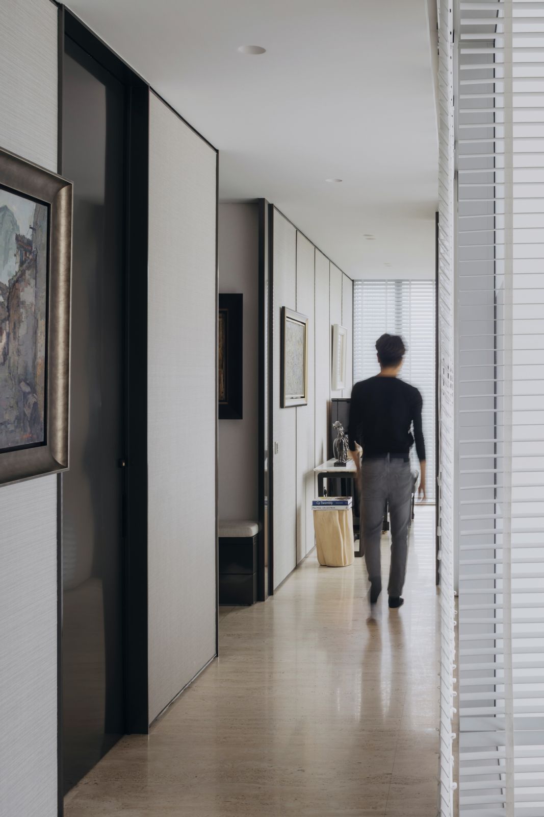 Artworks and metal trims serve to break up the uniformity of this elongated corridor wall
