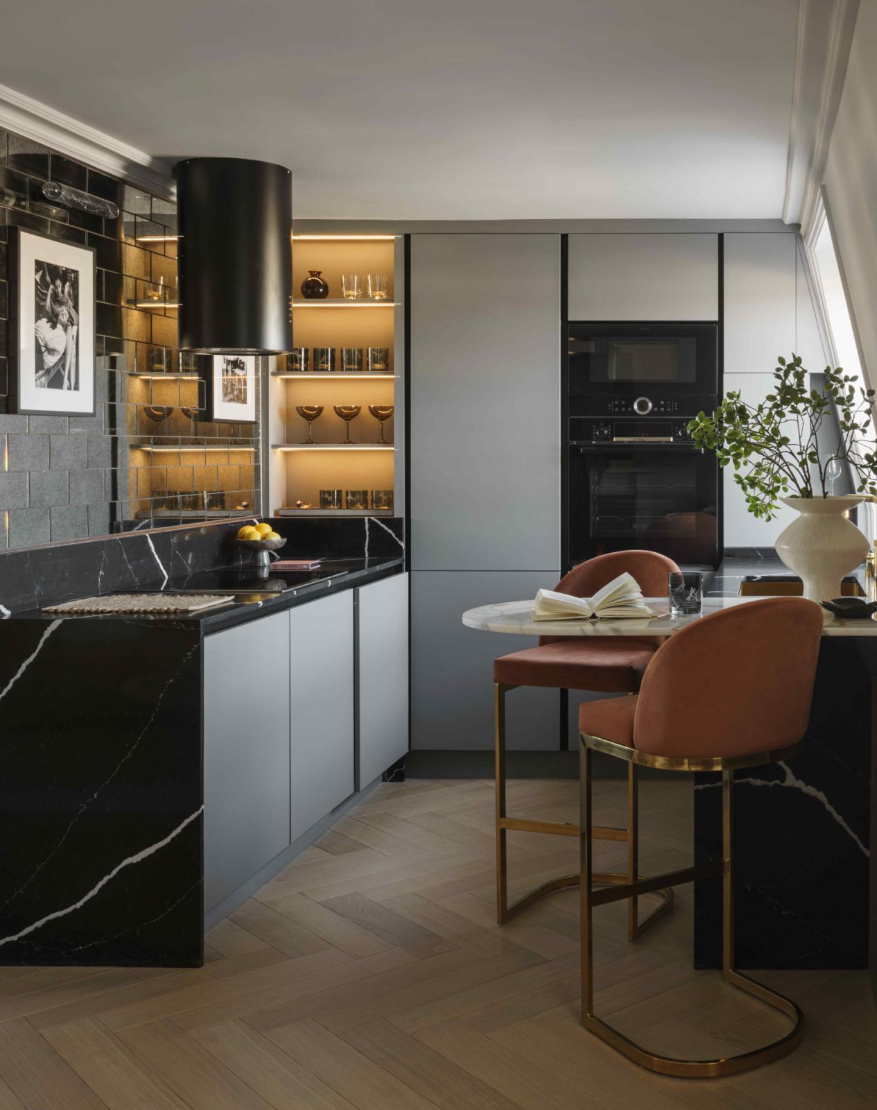 The kitchen area with bleached oak flooring and marble surfaces