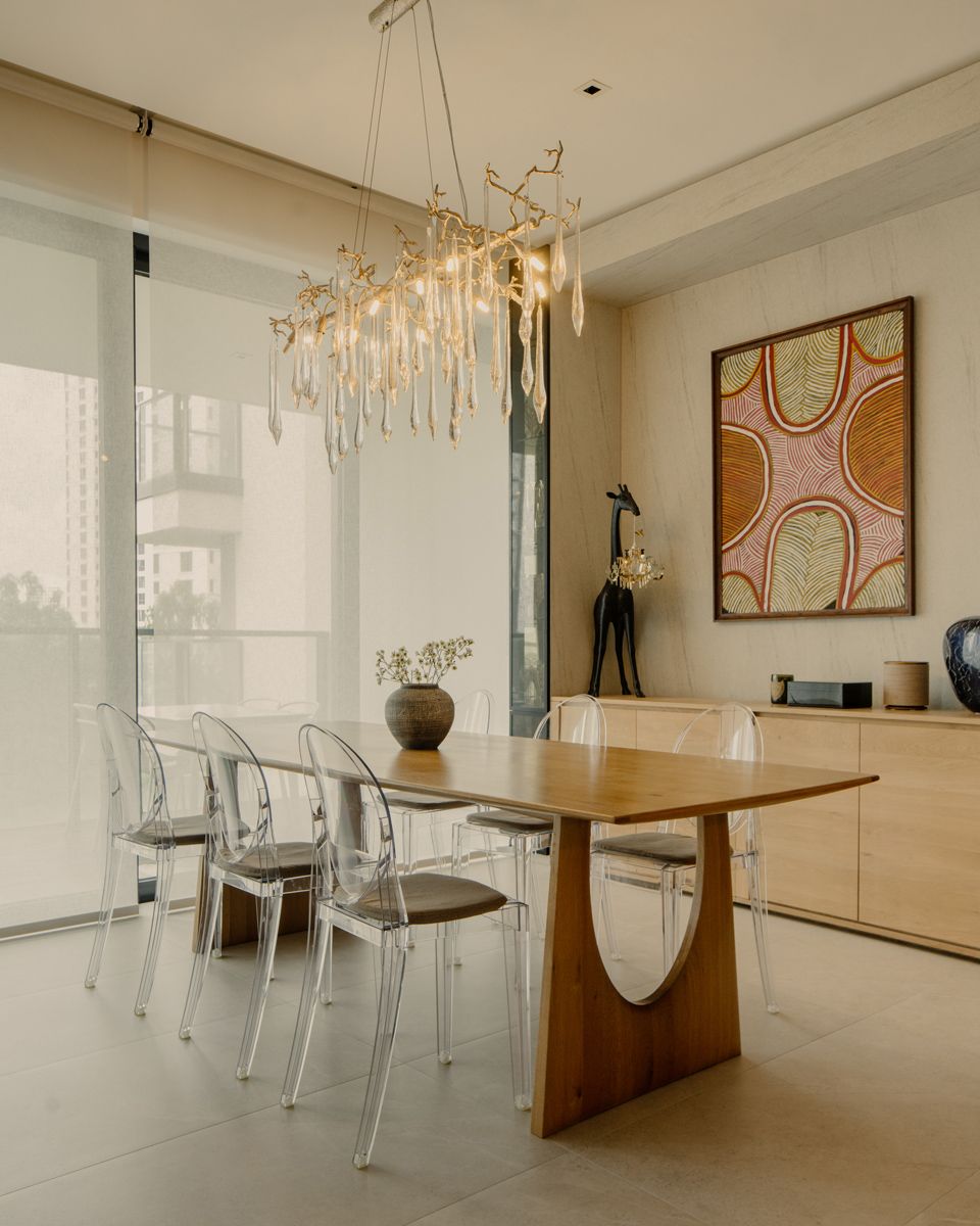 The dining room features Kartell Ghost Chairs by Philippe Starck