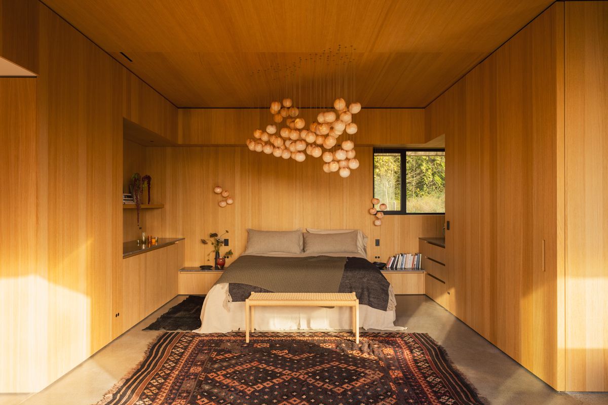 The bedroom is a cosy space lit by Bocci pendant lights
