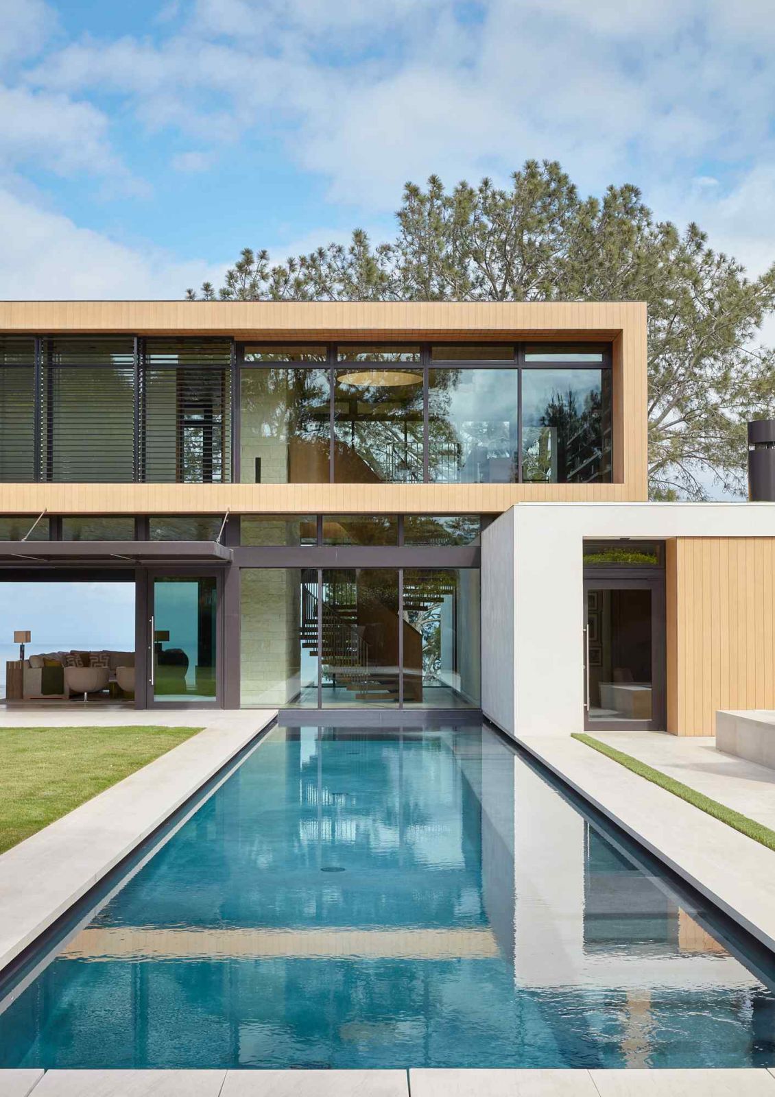 Cedar-clad wood and white plaster bars accentuated by floor-to-ceiling glass and the pool